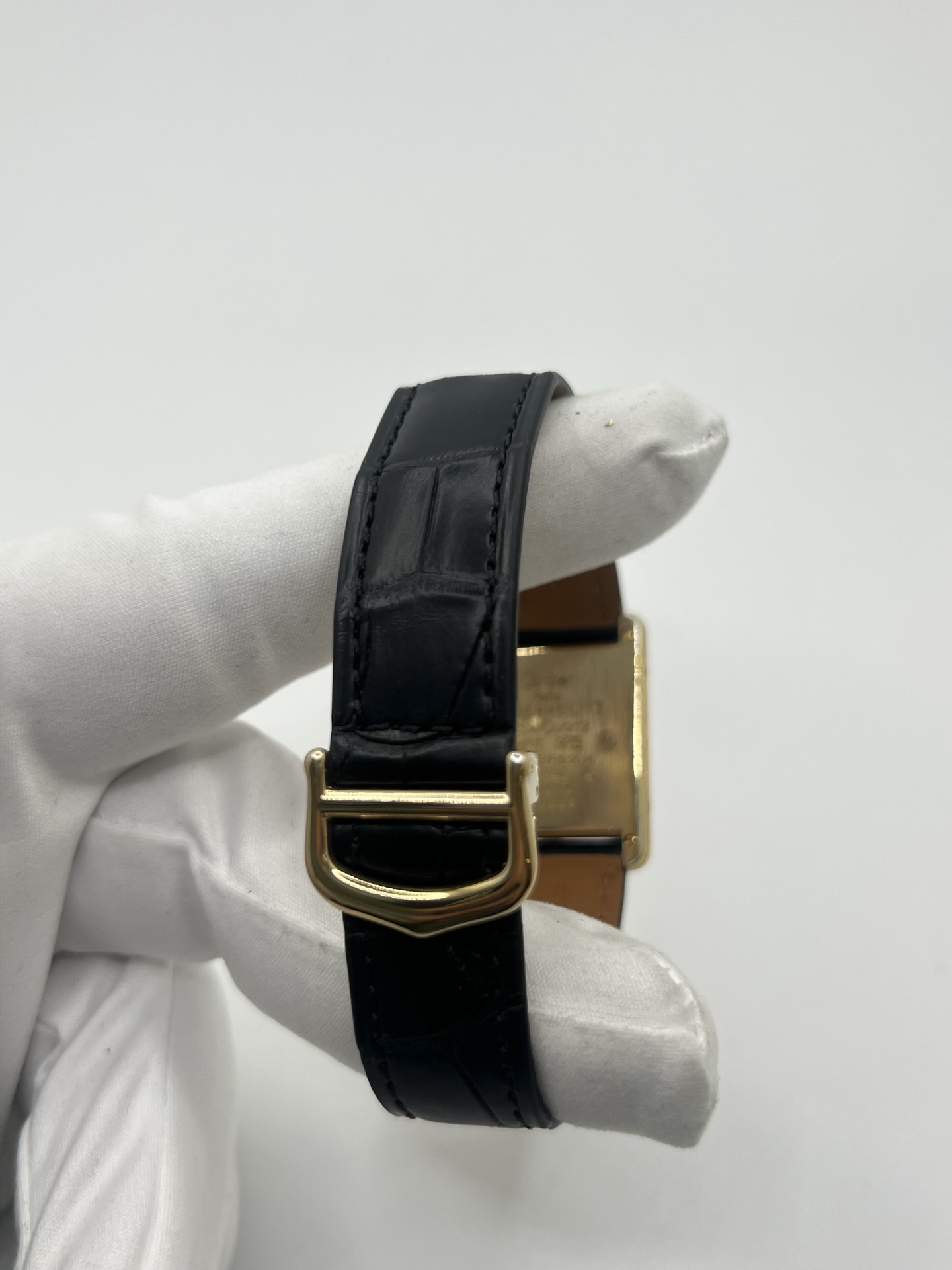Montre Cartier Tank Must Trinity Grand Modèle vintage en vermeil, référence 590005, datant des années 1990. Boîtier rectangulaire de 23 x 30 mm en argent vermeil, cadran blanc à chiffres romains avec motif Trinity emblématique, verre saphir et mouvement quartz Cartier calibre 90. Bracelet en cuir avec boucle Cartier. Cette montre de luxe au design intemporel incarne l’élégance française et l’héritage horloger de Cartier, recherchée par les collectionneurs de montres vintage.