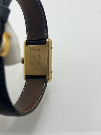 Montre Cartier Tank Must Vermeil référence 5057001 pour femme, boîtier en argent 20 x 28 mm, cadran noir sans chiffres et bracelet en cuir de lézard noir. Modèle à mouvement quartz, en bon état avec traces d’usure légères. Montre élégante au style intemporel, idéale pour un look sophistiqué et raffiné. Parfaite pour les amateurs de pièces vintage.