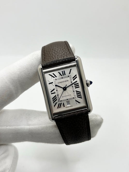 Montre Cartier Tank Solo XL WSTA0040 en acier, équipée d’un mouvement automatique et d’un boîtier de 31 × 41 mm. Son cadran argenté est protégé par un verre saphir, offrant une excellente résistance au quotidien. Cette Cartier Tank Solo XL est montée sur un bracelet brun en cuir de vache avec boucle déployante en acier. Dotée d’un affichage de la date et étanche à 3 ATM, elle associe élégance, sobriété et raffinement. Modèle de 2021, en très bon état.