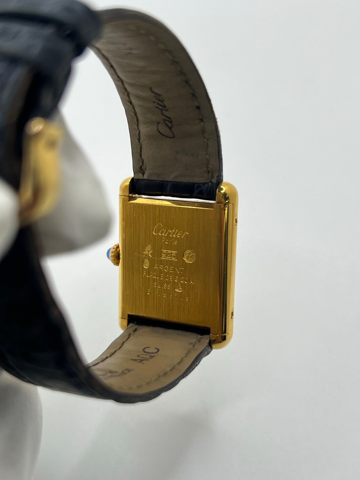 Montre Cartier Must de Cartier Tank Trinity en argent, à remontage manuel, avec boîtier de 23 x 30 mm et cadran jaune sans chiffres. Ce modèle emblématique est équipé d’un bracelet en cuir bleu avec boucle ardillon en acier, d’un verre minéral et d’une lunette en argent. Montre de luxe vintage homme ou unisexe, d’occasion en bon état, présentant des traces d’usure visibles. Révisée en interne, livrée avec coffret d’origine, idéale pour les collectionneurs de montres Cartier Tank Trinity.