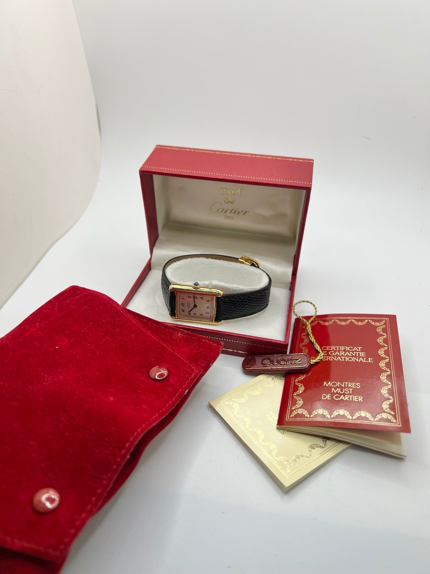 Montre Cartier Tank Vermeil référence 590005 vintage de 1989, avec boîtier rectangulaire en argent aux proportions classiques 23 x 30 mm, cadran argenté élégant avec chiffres arabes noirs et aiguilles bleuies, verre saphir et mouvement quartz. Montée sur un bracelet en cuir de lézard noir avec boucle ardillon en acier. Modèle iconique au design intemporel, livré avec son coffret et ses papiers d’origine, en très bon état.