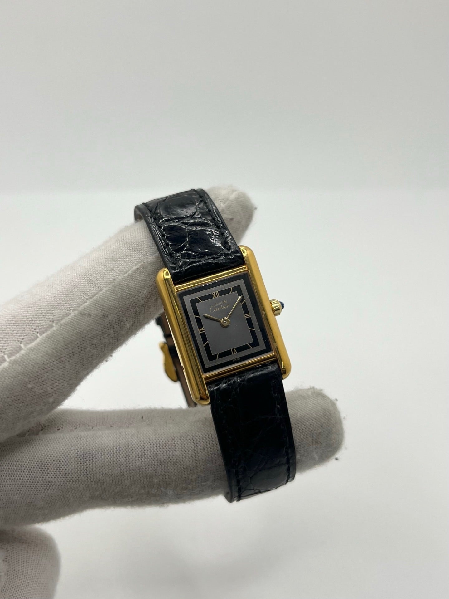 Montre Cartier Tank Vermeil 3 66001 pour femme, équipée d’un mouvement quartz et d’un boîtier en argent de 20 x 27 mm. Ce modèle d’occasion en très bon état présente un cadran or à chiffres romains, un verre minéral et un bracelet en cuir de crocodile noir avec boucle en acier. Élégante et intemporelle, la Cartier Tank Vermeil 3 66001 séduit par son design classique, idéale pour les passionnées de montres de luxe raffinées.
