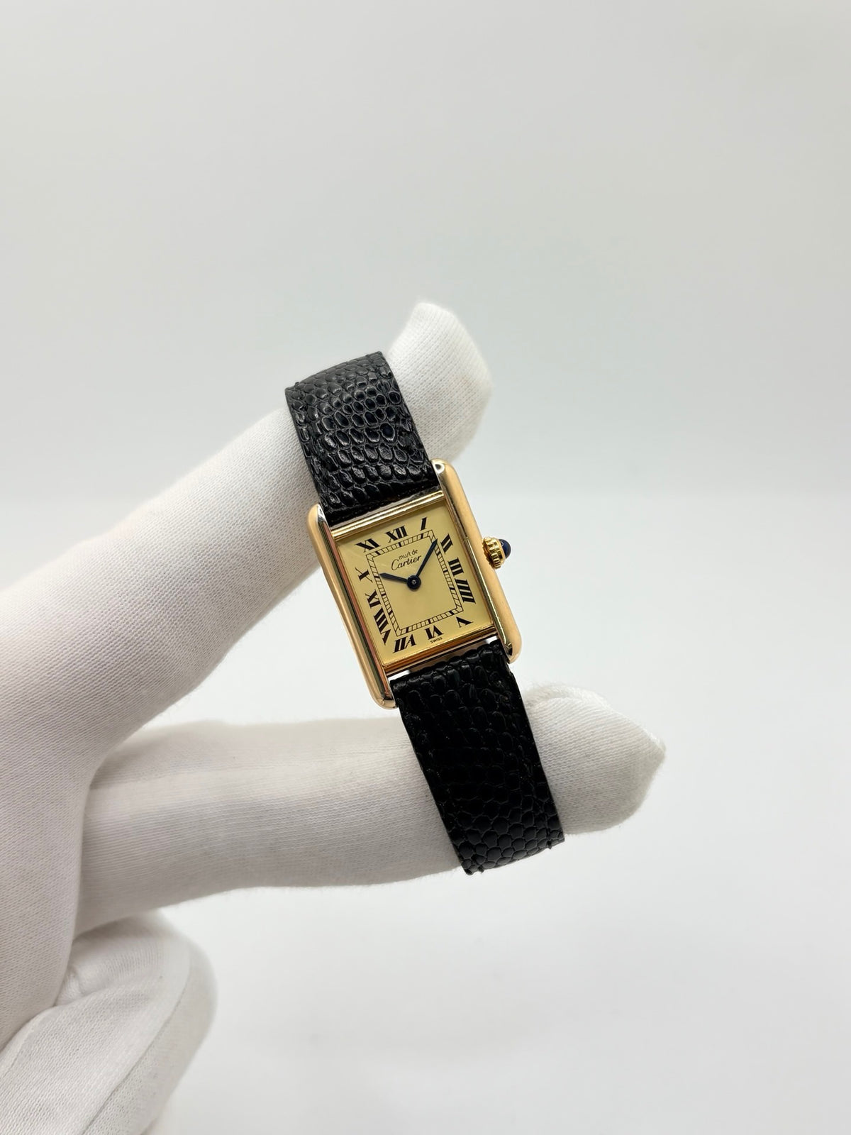 Montre Cartier Tank Vermeil 5057001 en très bon état, équipée d’un mouvement quartz et d’un boîtier en argent de 20 × 28 mm. Son cadran blanc à chiffres romains est protégé par un verre minéral. Cette montre Cartier Tank Vermeil possède un bracelet en cuir de lézard noir avec boucle ardillon en acier. Livrée avec son coffret d’origine, elle séduit par son design élégant et intemporel, emblématique de la collection Tank.