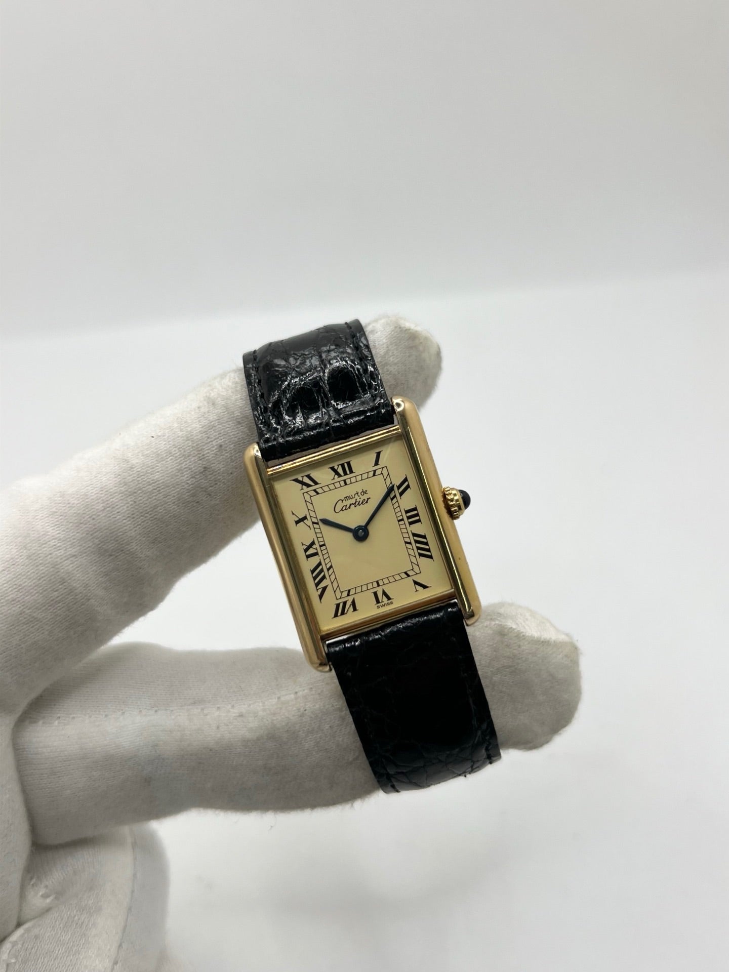 Montre Cartier Tank Vermeil réf. 590005 en argent avec mouvement à quartz, cadran champagne à chiffres romains et verre saphir. Ce modèle emblématique est monté sur un bracelet en cuir de crocodile noir avec boucle ardillon en acier. Son boîtier de 23 × 30 mm offre une élégance intemporelle. Cette montre Cartier Tank Vermeil d'occasion est en très bon état, révisée en interne et livrée avec son coffret d'origine.