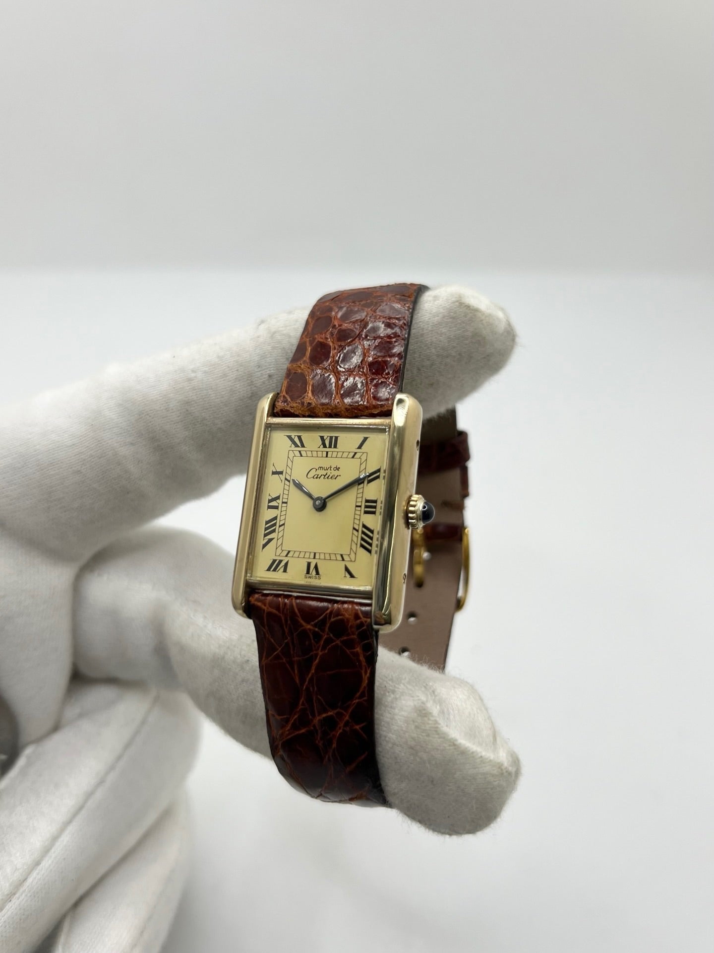 Cartier Tank Must Vermeil en argent avec boîtier rectangulaire de 23 x 30 mm, mouvement à remontage manuel et cadran champagne à chiffres romains. Cette montre unisexe est équipée d’un bracelet en cuir brun avec boucle ardillon en acier et d’un verre saphir. Modèle d’occasion en très bon état, révisé en interne en 2026. Une montre Cartier élégante et intemporelle, livrée avec coffret d’origine, sans papiers d’origine.
