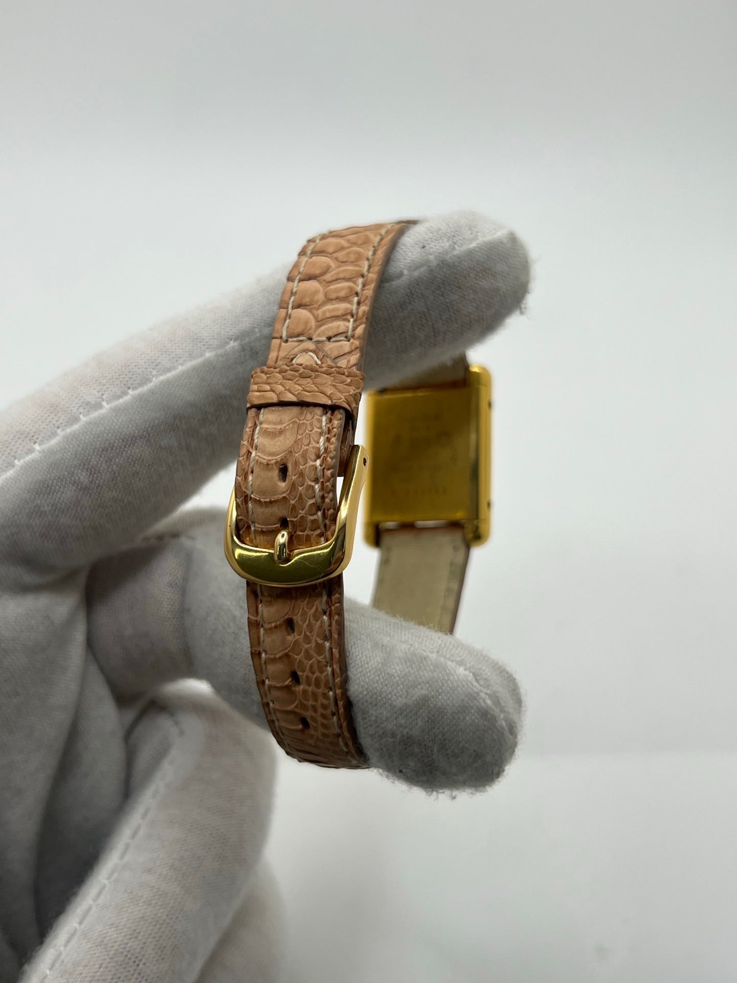 Montre femme Tank Must Vermeil Trinity référence 3 66001, boîtier en argent aux dimensions 21 x 28 mm, mouvement mécanique à remontage manuel. Cadran de couleur or sans chiffres, verre minéral, lunette en argent. Bracelet en cuir beige avec boucle ardillon en acier. Montre d’occasion en très bon état, présentant de légères traces d’usure superficielles non perceptibles au toucher. Modèle emblématique au design rectangulaire élégant.