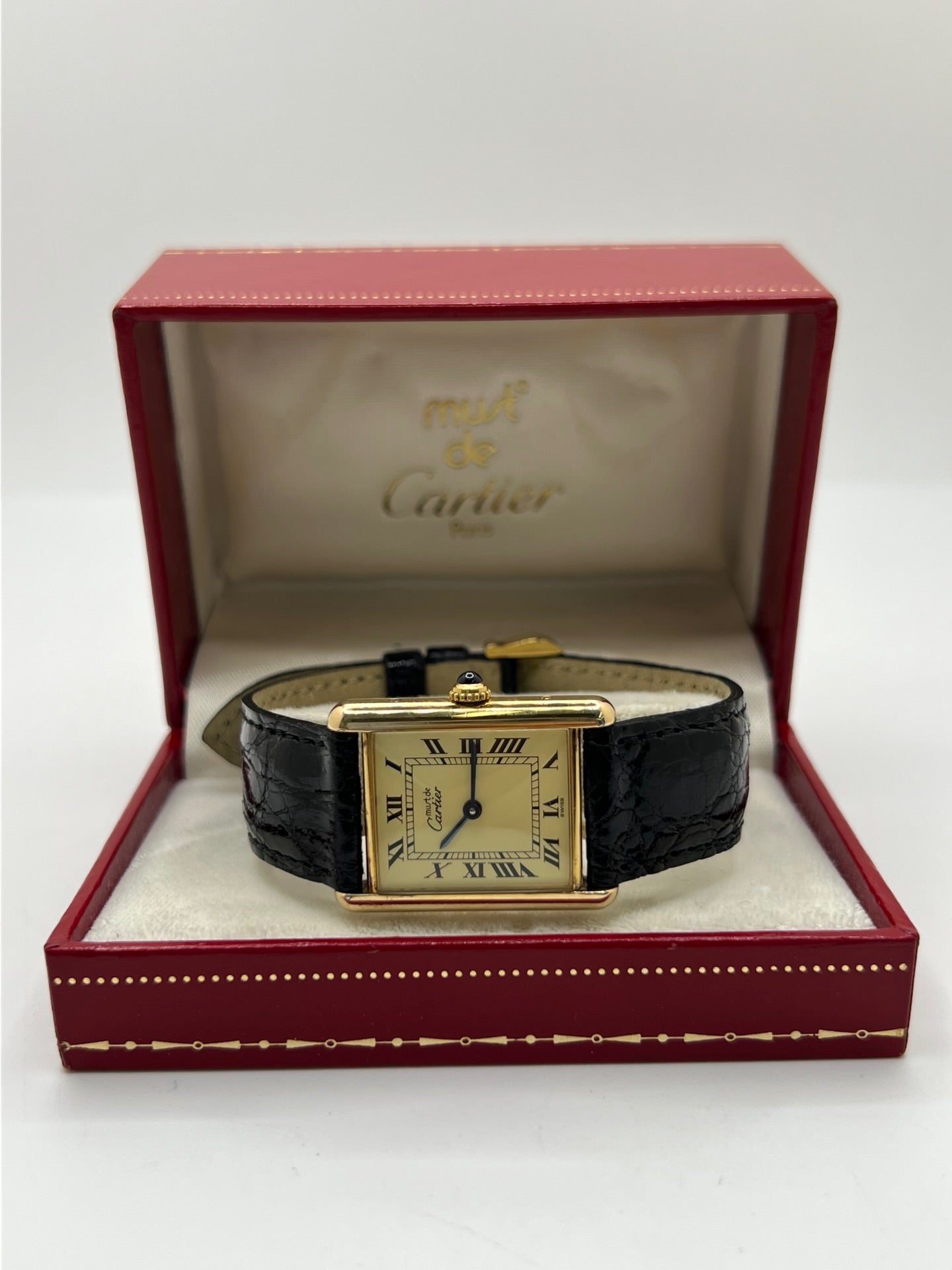 Montre Cartier Tank Vermeil réf. 590005 en argent avec mouvement à quartz, cadran champagne à chiffres romains et verre saphir. Ce modèle emblématique est monté sur un bracelet en cuir de crocodile noir avec boucle ardillon en acier. Son boîtier de 23 × 30 mm offre une élégance intemporelle. Cette montre Cartier Tank Vermeil d'occasion est en très bon état, révisée en interne et livrée avec son coffret d'origine.