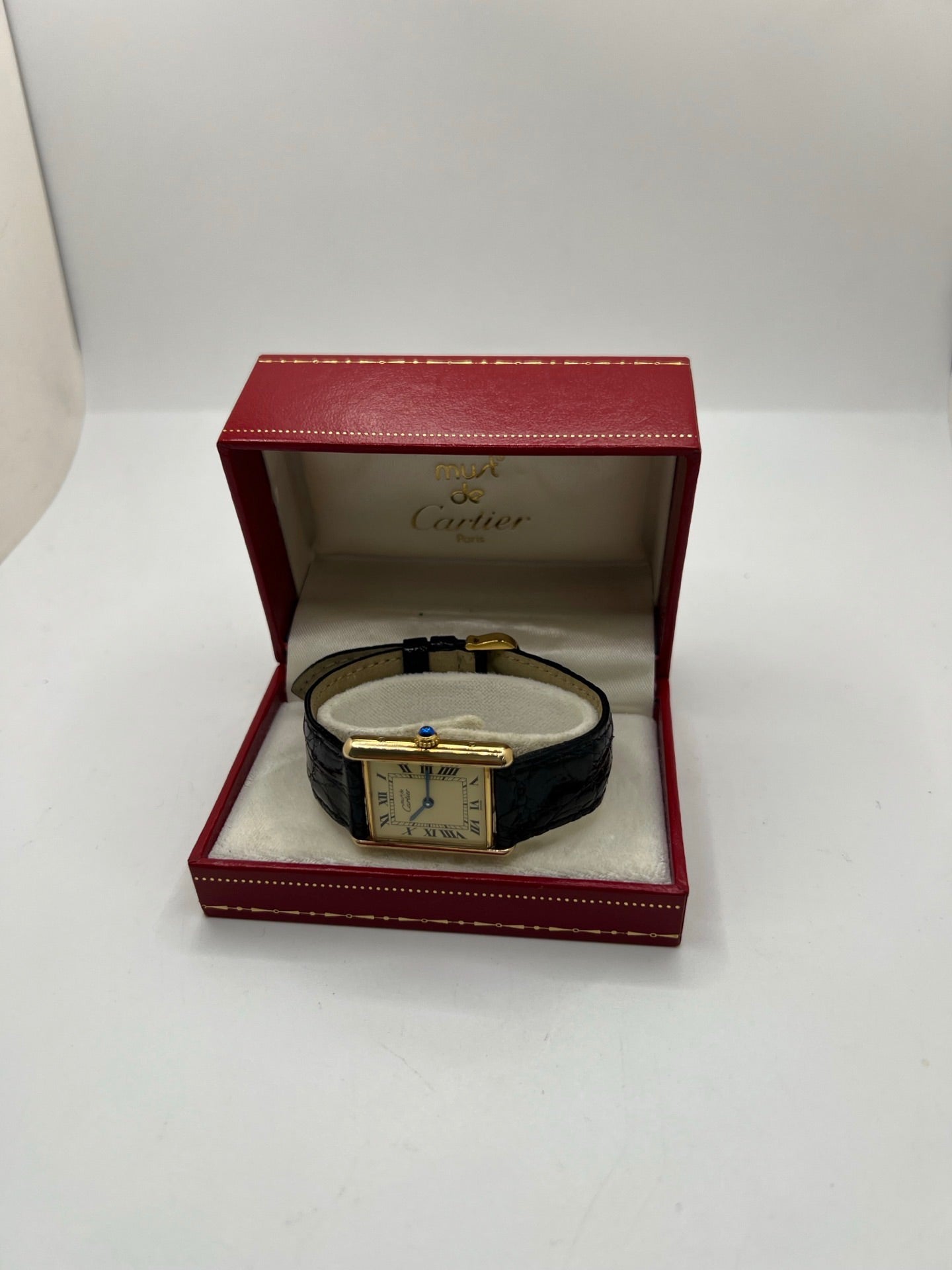 Montre Cartier Tank Vermeil réf. 590005 en argent avec mouvement à quartz, cadran champagne à chiffres romains et verre saphir. Ce modèle emblématique est monté sur un bracelet en cuir de crocodile noir avec boucle ardillon en acier. Son boîtier de 23 × 30 mm offre une élégance intemporelle. Cette montre Cartier Tank Vermeil d'occasion est en très bon état, révisée en interne et livrée avec son coffret d'origine.