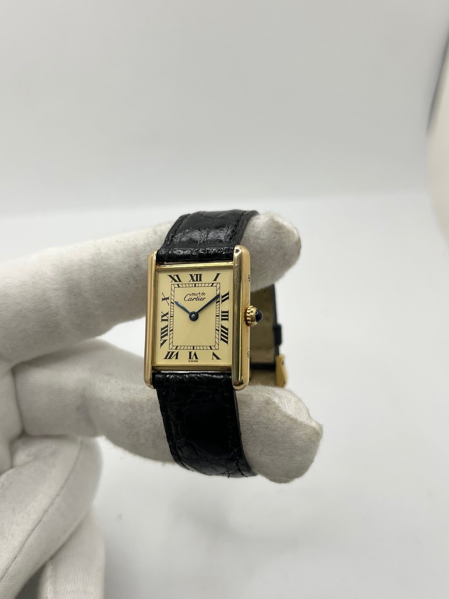 Montre Cartier Tank Vermeil réf. 590005 en argent avec mouvement à quartz, cadran champagne à chiffres romains et verre saphir. Ce modèle emblématique est monté sur un bracelet en cuir de crocodile noir avec boucle ardillon en acier. Son boîtier de 23 × 30 mm offre une élégance intemporelle. Cette montre Cartier Tank Vermeil d'occasion est en très bon état, révisée en interne et livrée avec son coffret d'origine.