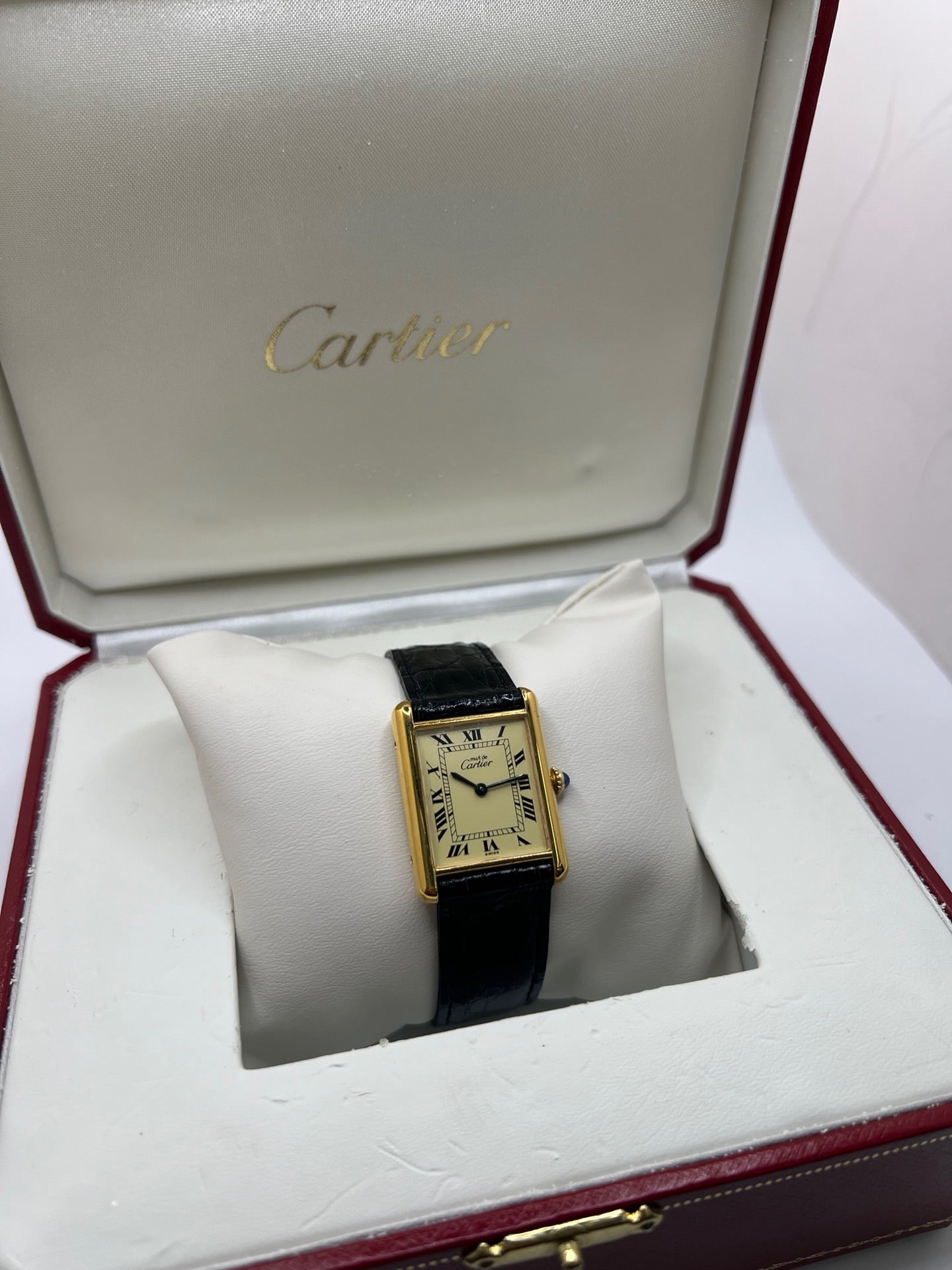Montre Cartier Tank Vermeil mécanique vintage en argent plaqué or, dotée d’un mouvement à remontage manuel. Ce modèle emblématique présente un cadran champagne à chiffres romains, un boîtier rectangulaire de 23 x 30 mm et un bracelet en cuir de crocodile noir avec boucle ardillon en acier. Élégante et intemporelle, cette montre Cartier Must Tank d’occasion en très bon état séduit les amateurs d’horlogerie classique et de montres de luxe vintage.
