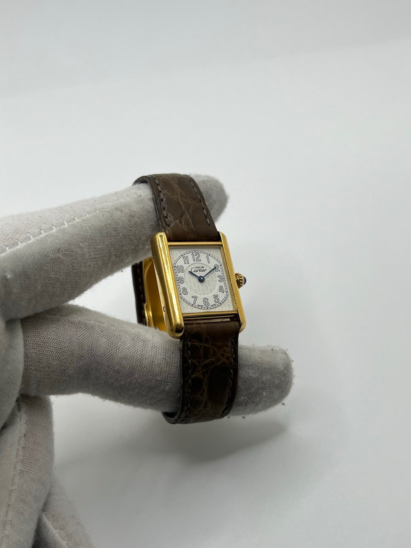 Montre Cartier Tank Vermeil 2415 pour femme, équipée d’un mouvement quartz et d’un boîtier en argent de 22 x 29 mm. Ce modèle d’occasion en bon état présente des traces d’usure visibles, un cadran blanc à chiffres arabes, un verre minéral et un bracelet en cuir brun avec boucle ardillon en argent. Élégante et classique, la Cartier Tank Vermeil 2415 séduit par son design intemporel, idéale pour les passionnées de montres de luxe.