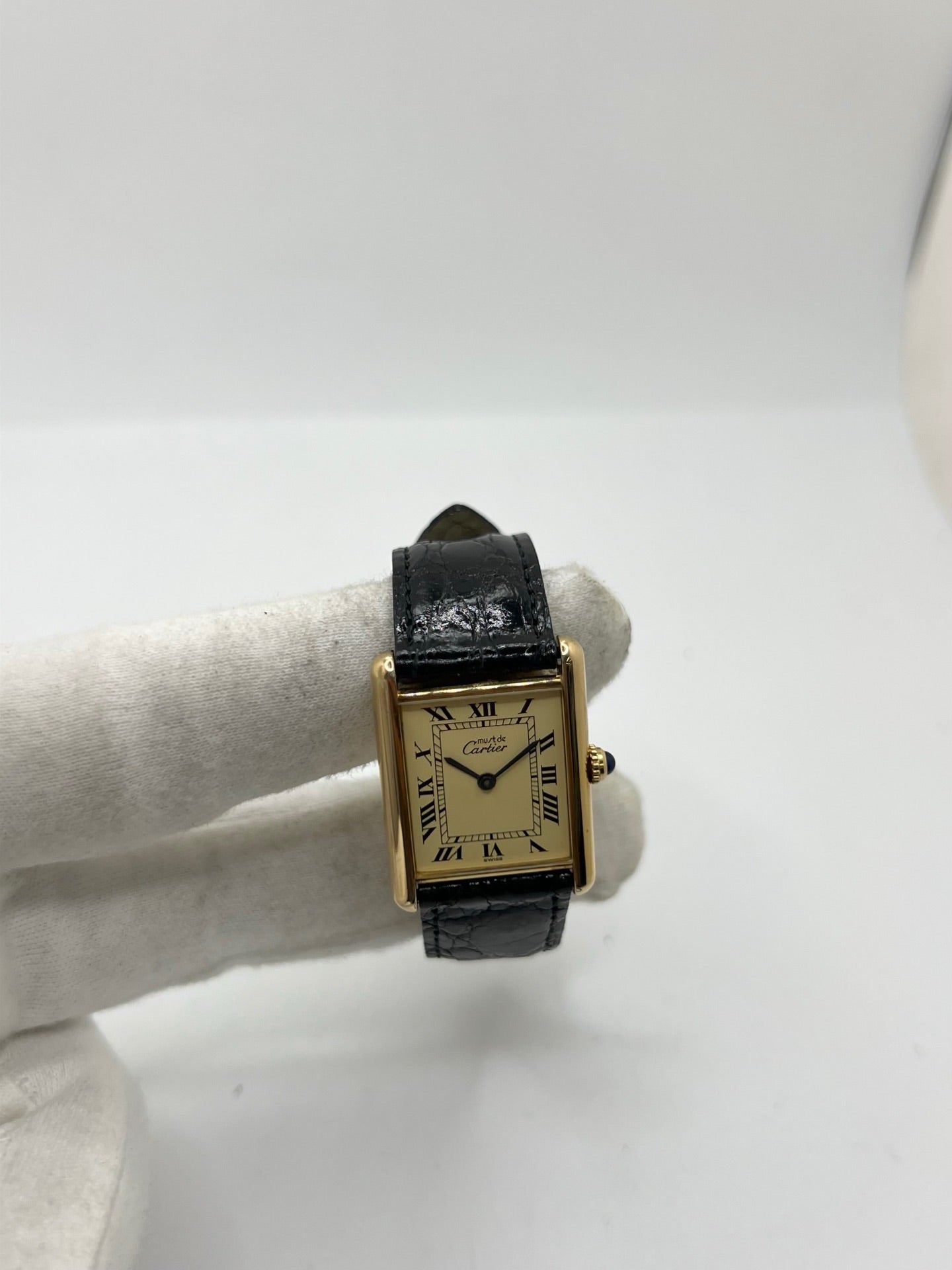 Montre Cartier Tank Vermeil réf. 590005 en argent avec mouvement à quartz, cadran champagne à chiffres romains et verre saphir. Ce modèle emblématique est monté sur un bracelet en cuir de crocodile noir avec boucle ardillon en acier. Son boîtier de 23 × 30 mm offre une élégance intemporelle. Cette montre Cartier Tank Vermeil d'occasion est en très bon état, révisée en interne et livrée avec son coffret d'origine.