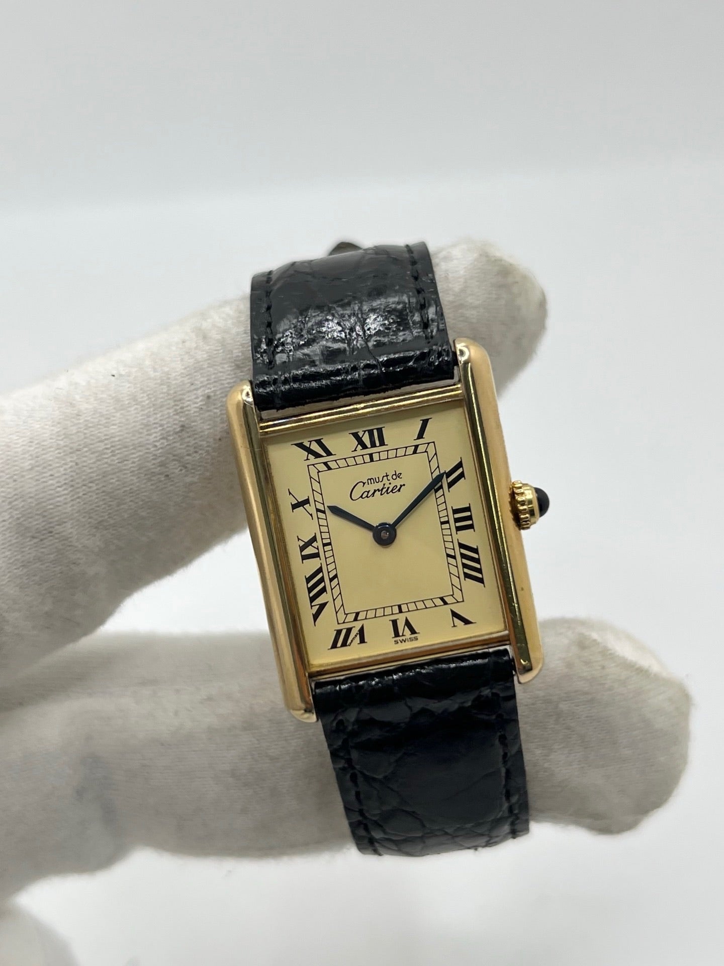 Montre Cartier Tank Vermeil réf. 590005 en argent avec mouvement à quartz, cadran champagne à chiffres romains et verre saphir. Ce modèle emblématique est monté sur un bracelet en cuir de crocodile noir avec boucle ardillon en acier. Son boîtier de 23 × 30 mm offre une élégance intemporelle. Cette montre Cartier Tank Vermeil d'occasion est en très bon état, révisée en interne et livrée avec son coffret d'origine.
