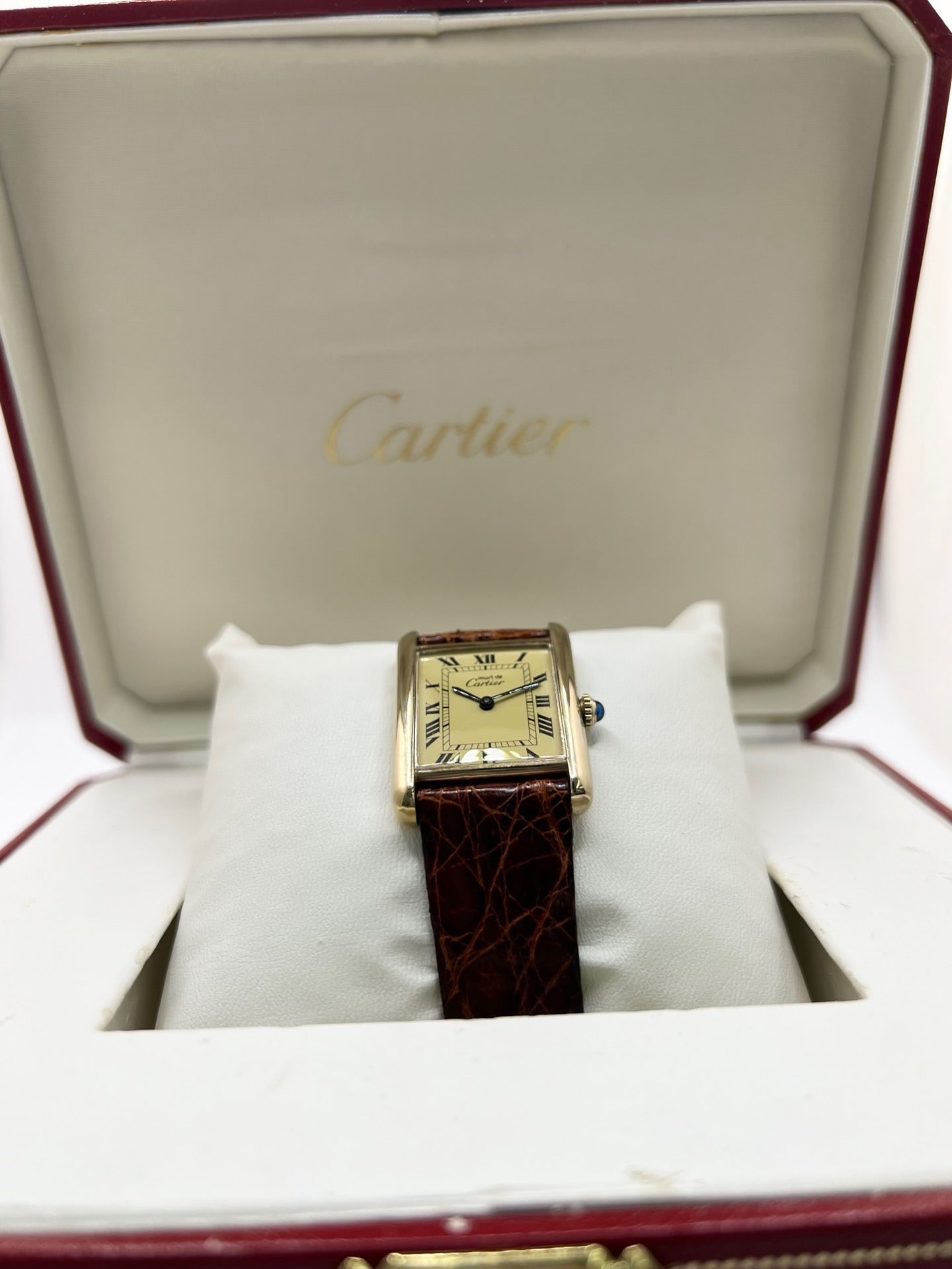 Cartier Tank Must Vermeil en argent avec boîtier rectangulaire de 23 x 30 mm, mouvement à remontage manuel et cadran champagne à chiffres romains. Cette montre unisexe est équipée d’un bracelet en cuir brun avec boucle ardillon en acier et d’un verre saphir. Modèle d’occasion en très bon état, révisé en interne en 2026. Une montre Cartier élégante et intemporelle, livrée avec coffret d’origine, sans papiers d’origine.
