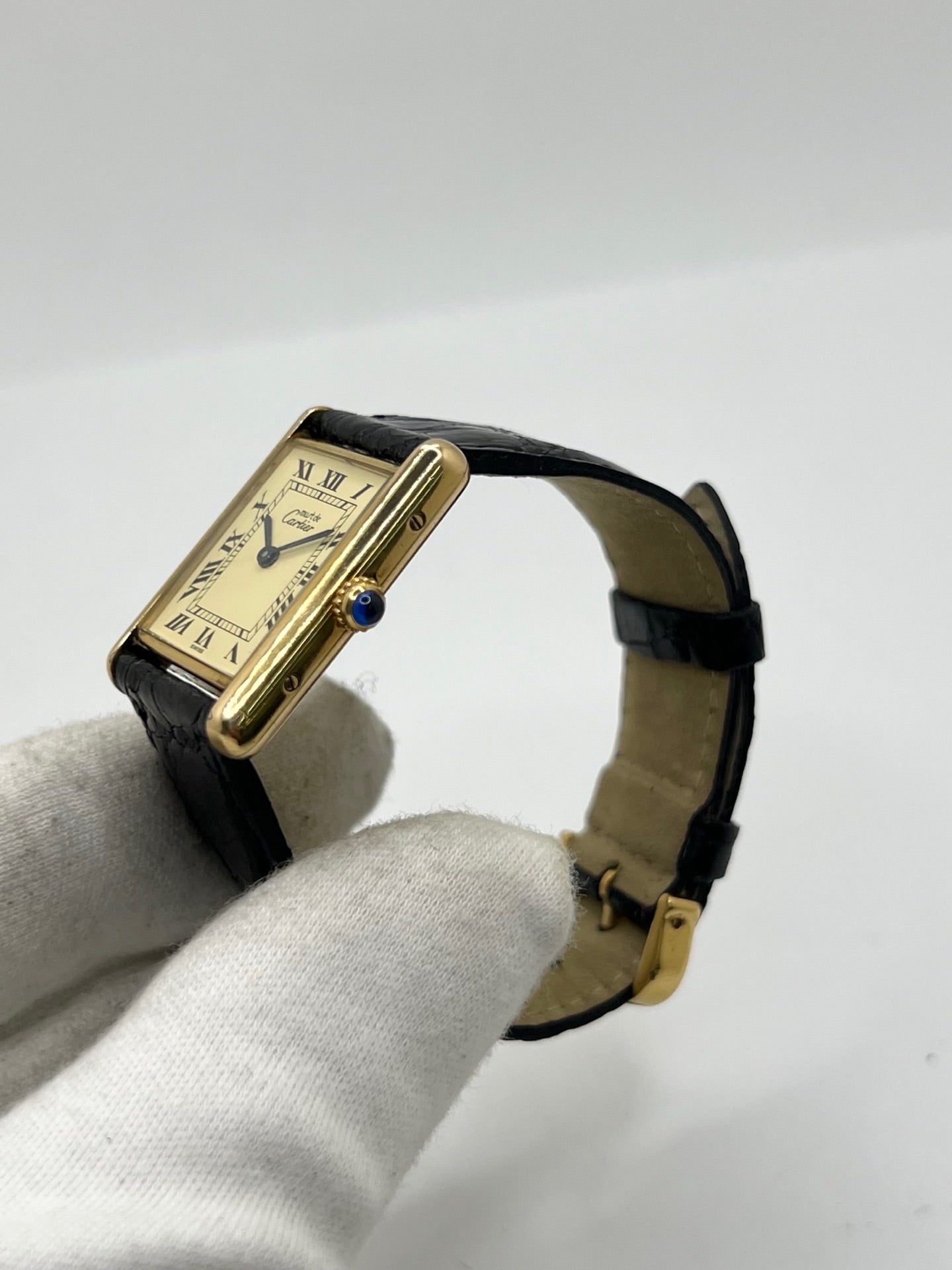 Montre Cartier Tank Vermeil réf. 590005 en argent avec mouvement à quartz, cadran champagne à chiffres romains et verre saphir. Ce modèle emblématique est monté sur un bracelet en cuir de crocodile noir avec boucle ardillon en acier. Son boîtier de 23 × 30 mm offre une élégance intemporelle. Cette montre Cartier Tank Vermeil d'occasion est en très bon état, révisée en interne et livrée avec son coffret d'origine.