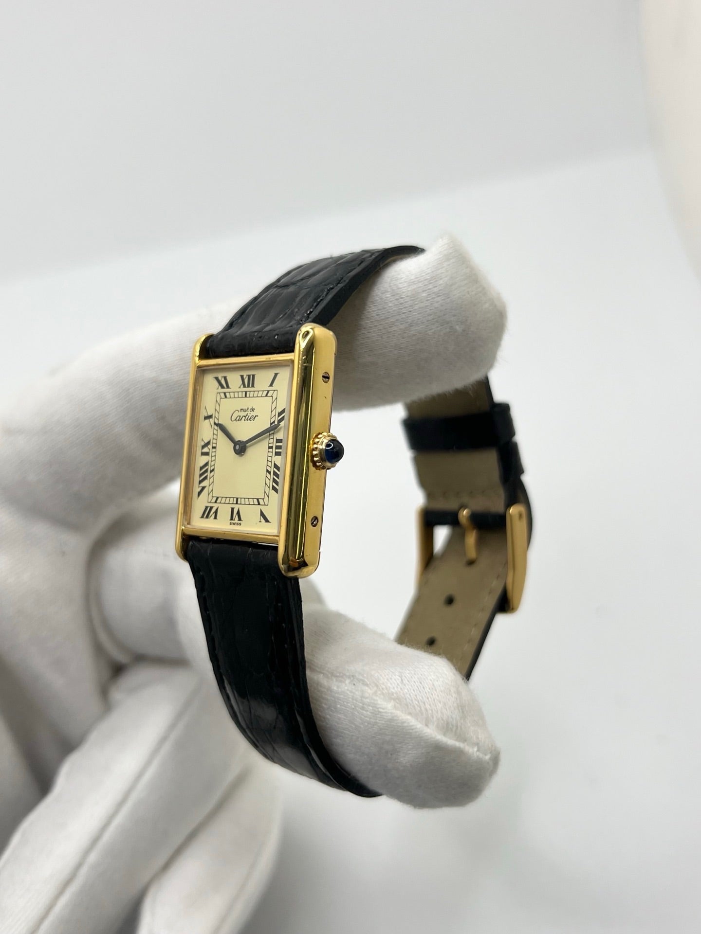 Montre Cartier Tank Vermeil mécanique vintage en argent plaqué or, dotée d’un mouvement à remontage manuel. Ce modèle emblématique présente un cadran champagne à chiffres romains, un boîtier rectangulaire de 23 x 30 mm et un bracelet en cuir de crocodile noir avec boucle ardillon en acier. Élégante et intemporelle, cette montre Cartier Must Tank d’occasion en très bon état séduit les amateurs d’horlogerie classique et de montres de luxe vintage.
