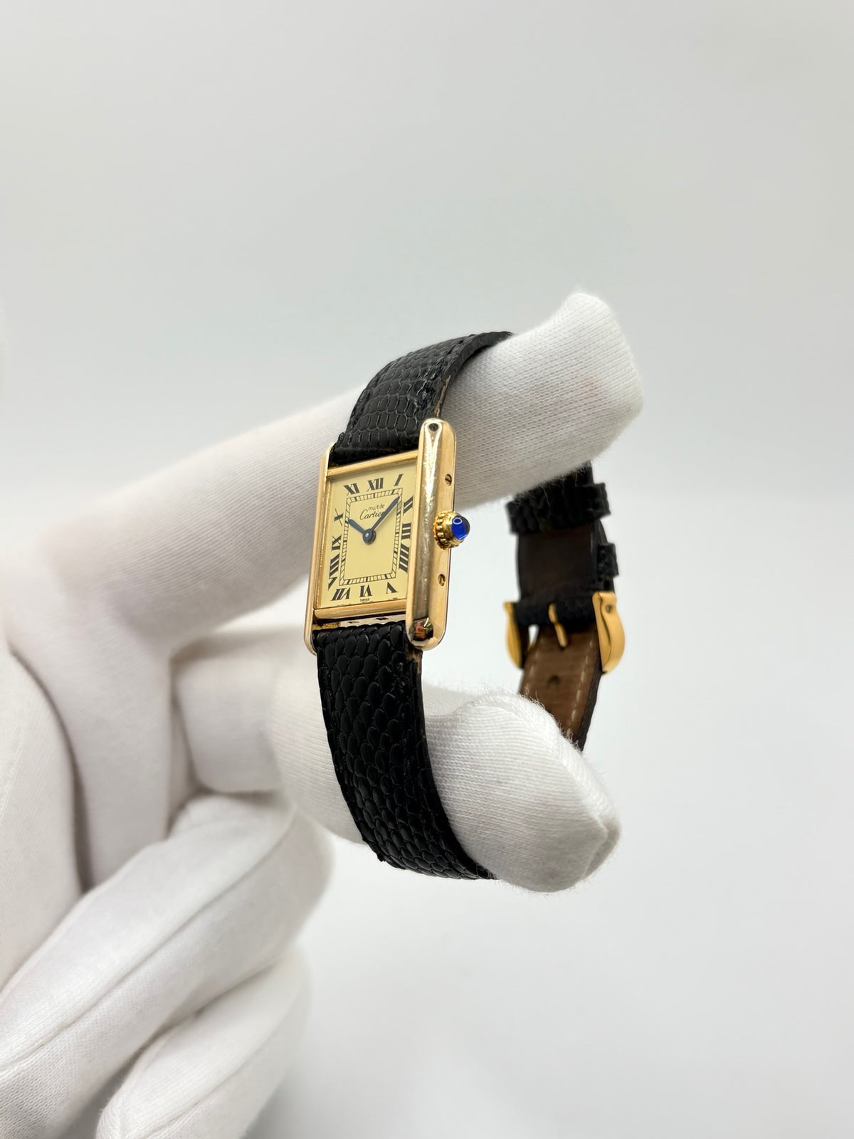 Montre Cartier Tank Vermeil 5057001 en très bon état, équipée d’un mouvement quartz et d’un boîtier en argent de 20 × 28 mm. Son cadran blanc à chiffres romains est protégé par un verre minéral. Cette montre Cartier Tank Vermeil possède un bracelet en cuir de lézard noir avec boucle ardillon en acier. Livrée avec son coffret d’origine, elle séduit par son design élégant et intemporel, emblématique de la collection Tank.