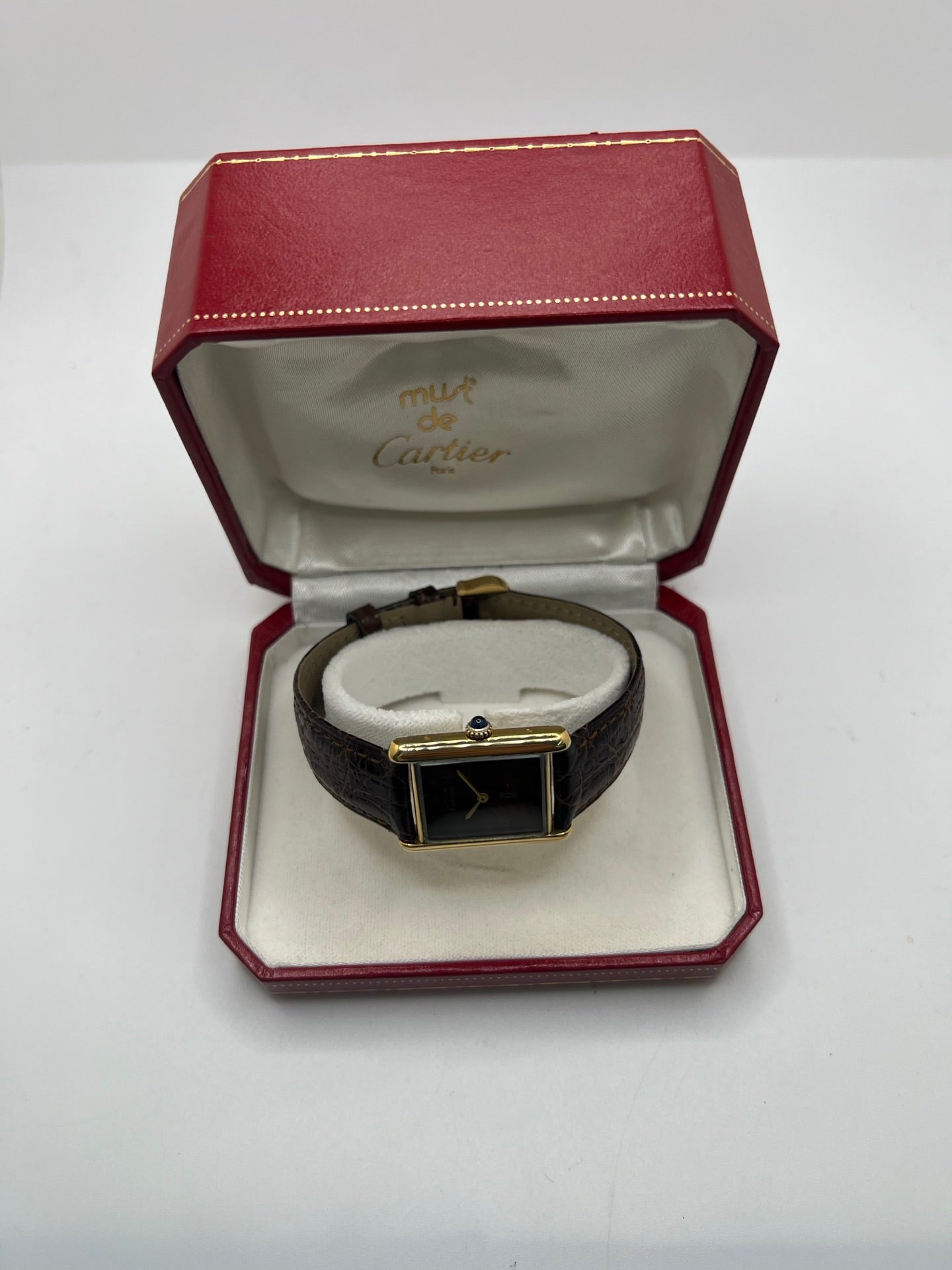 Montre Cartier Tank Must Vermeil Œil de Tigre vintage avec boîtier rectangulaire en vermeil, mouvement à remontage manuel et cadran en pierre naturelle œil de tigre aux reflets bruns et dorés. Cette Cartier Must Tank Vermeil se distingue par son design emblématique, son bracelet en cuir brun et son élégance intemporelle. Montre de collection recherchée par les amateurs de montres Cartier vintage, alliant raffinement, caractère et savoir-faire horloger.