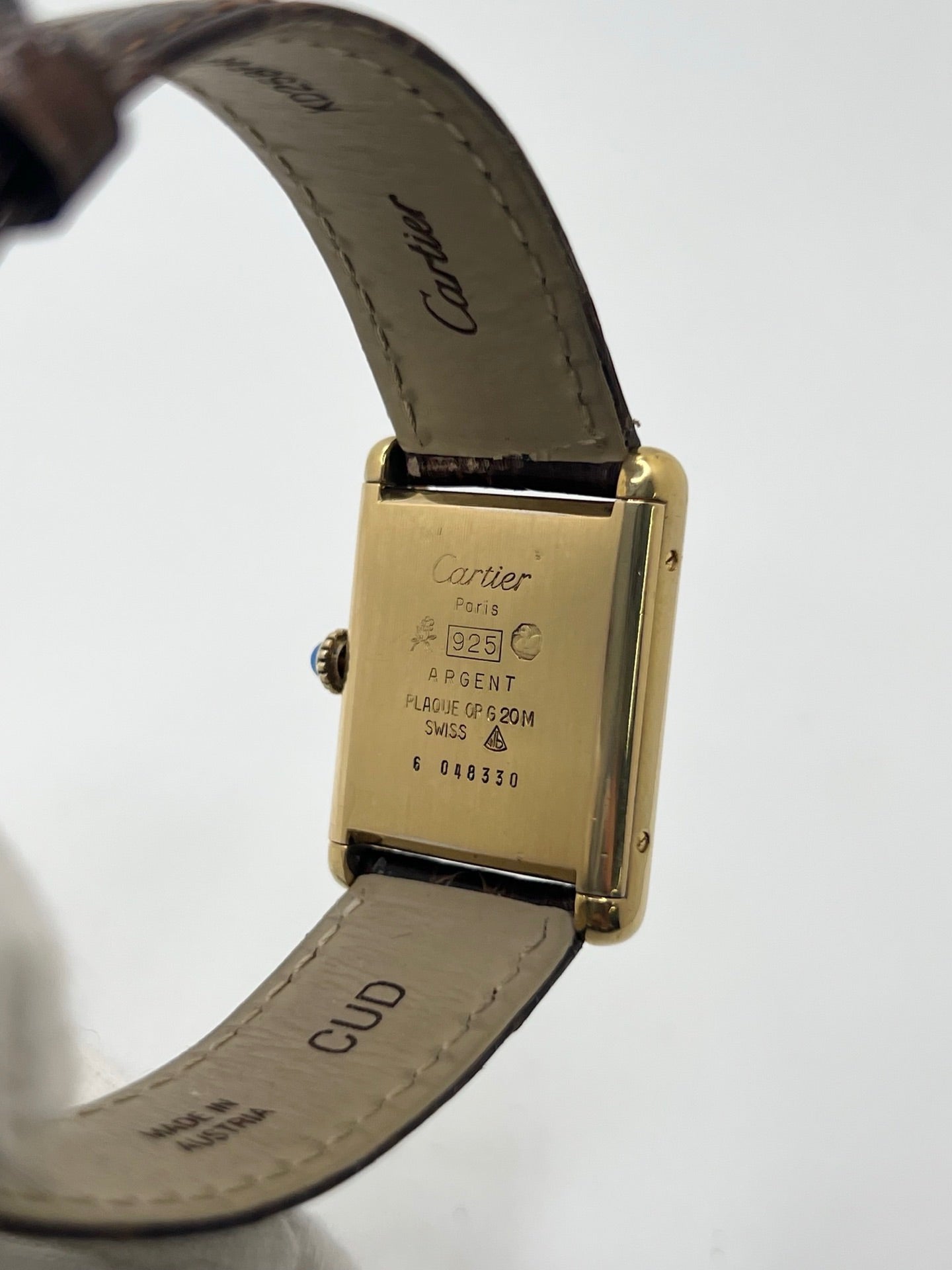 Montre Cartier Tank Must Vermeil Œil de Tigre vintage avec boîtier rectangulaire en vermeil, mouvement à remontage manuel et cadran en pierre naturelle œil de tigre aux reflets bruns et dorés. Cette Cartier Must Tank Vermeil se distingue par son design emblématique, son bracelet en cuir brun et son élégance intemporelle. Montre de collection recherchée par les amateurs de montres Cartier vintage, alliant raffinement, caractère et savoir-faire horloger.