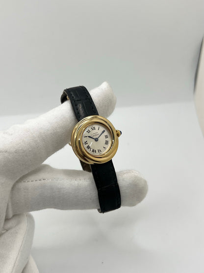 Montre Cartier Trinity référence 2735 pour femme en argent avec boîtier de 27 mm, cadran blanc à chiffres romains et verre saphir. Cette montre Cartier Trinity à mouvement quartz est équipée d’un bracelet en cuir avec boucle déployante en acier. Son design intemporel et élégant en fait une montre de luxe vintage idéale pour les collectionneuses ou pour un usage quotidien. Modèle d’occasion en très bon état, avec de légères traces d’usure, livré avec son coffret d’origine.