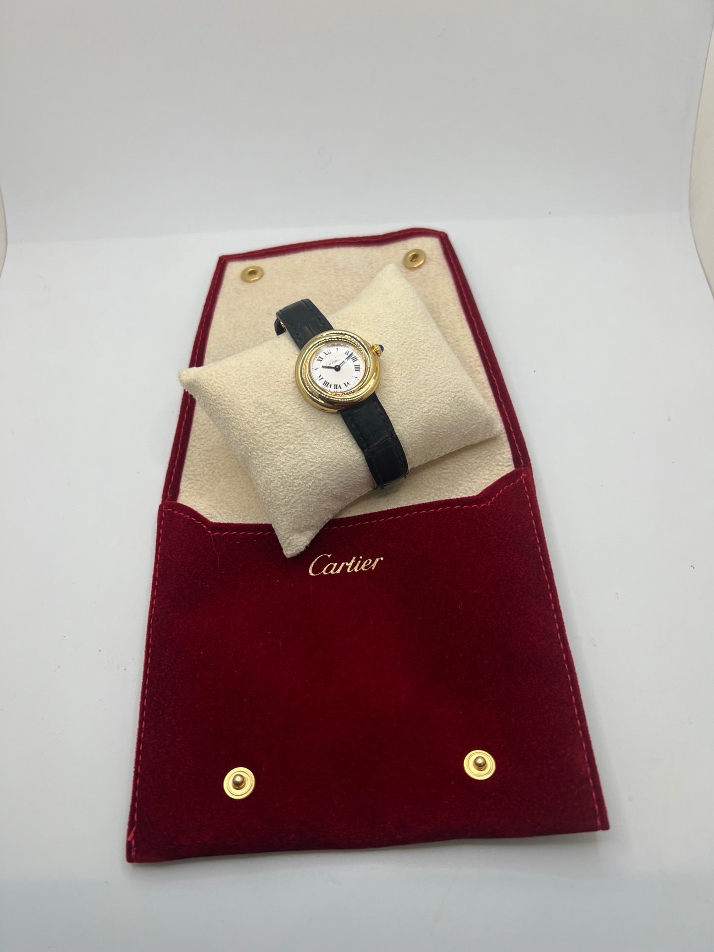 Montre Cartier Trinity référence 2735 pour femme en argent avec boîtier de 27 mm, cadran blanc à chiffres romains et verre saphir. Cette montre Cartier Trinity à mouvement quartz est équipée d’un bracelet en cuir avec boucle déployante en acier. Son design intemporel et élégant en fait une montre de luxe vintage idéale pour les collectionneuses ou pour un usage quotidien. Modèle d’occasion en très bon état, avec de légères traces d’usure, livré avec son coffret d’origine.