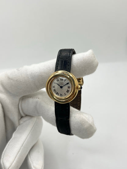 Montre Cartier Trinity référence 2735 pour femme en argent avec boîtier de 27 mm, cadran blanc à chiffres romains et verre saphir. Cette montre Cartier Trinity à mouvement quartz est équipée d’un bracelet en cuir avec boucle déployante en acier. Son design intemporel et élégant en fait une montre de luxe vintage idéale pour les collectionneuses ou pour un usage quotidien. Modèle d’occasion en très bon état, avec de légères traces d’usure, livré avec son coffret d’origine.