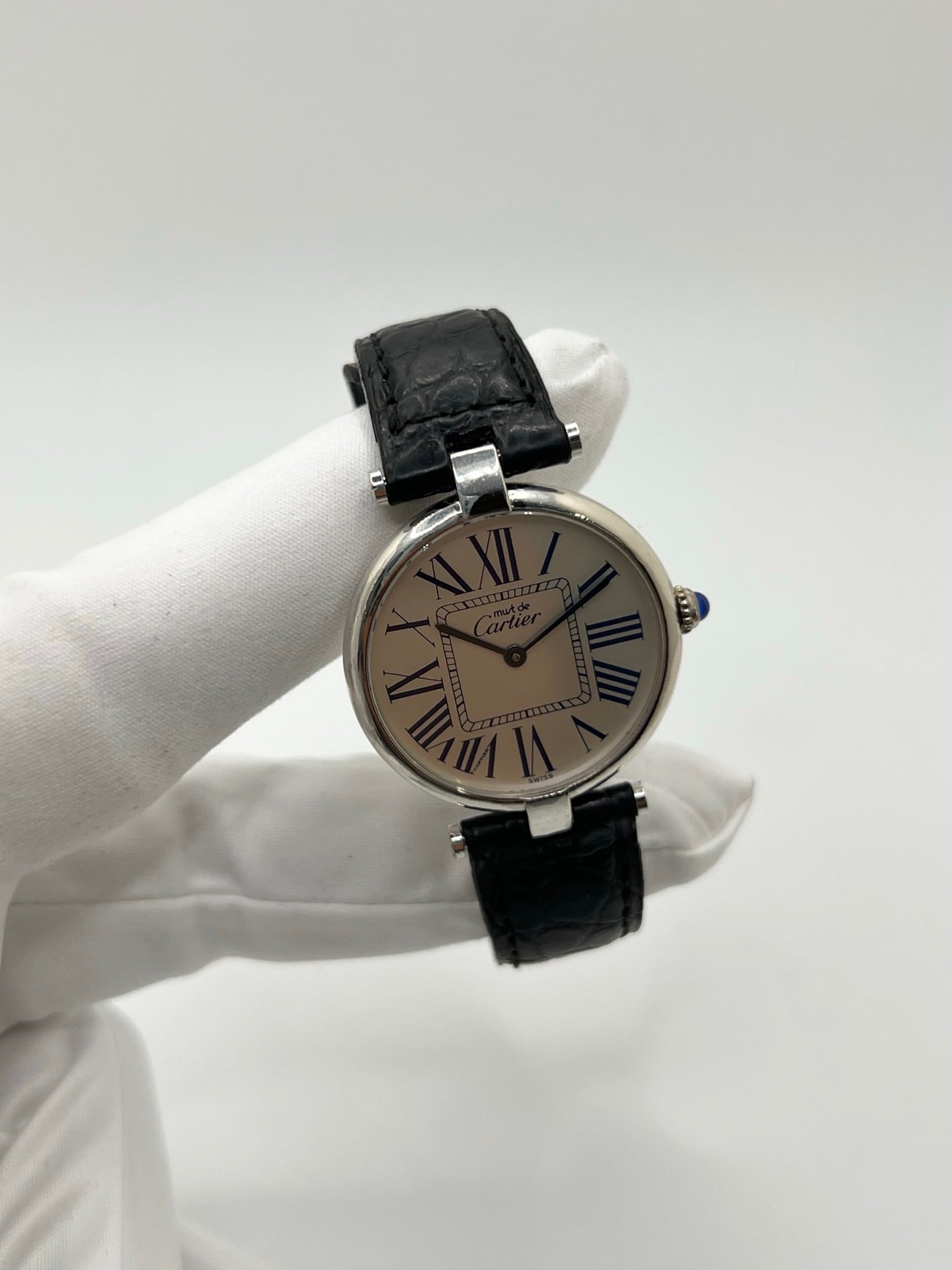 Montre Cartier Must Vendôme référence 1860 avec boîtier rond en argent de 30 mm et cadran argent à chiffres romains signature. Mouvement quartz fiable et élégant, protégé par un verre. Bracelet en cuir noir avec boucle ardillon offrant un porté confortable et raffiné. Modèle emblématique au style classique et intemporel, idéal pour une tenue habillée ou une collection de montres vintage. Montre d’occasion en très bon état, révisée et prête à être portée au quotidien.