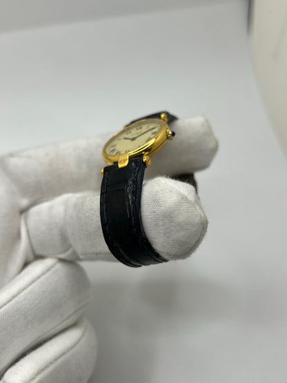 Montre Cartier Must Vendôme en vermeil, boîtier en argent plaqué or au diamètre de 30 mm, accompagnée d’un cadran blanc à chiffres romains signature. Équipée d’un mouvement quartz précis et d’un bracelet en cuir noir avec boucle en acier. Modèle élégant et intemporel, idéal pour un poignet féminin. Montre d’occasion en très bon état, présentant de légères micro-rayures, révisée en interne, livrée avec son coffret d’origine.