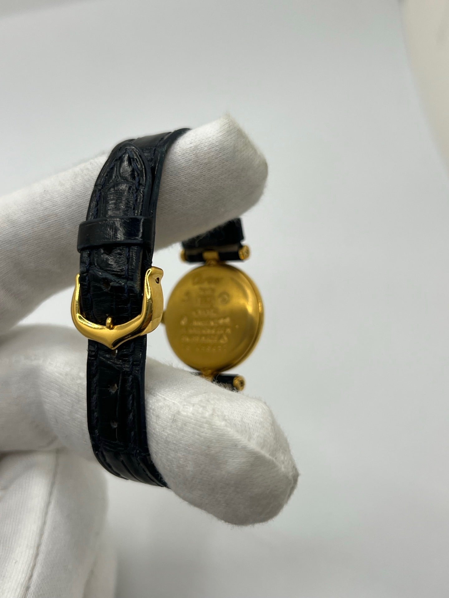 Montre Cartier Must Vendôme en vermeil, boîtier en argent plaqué or au diamètre de 30 mm, accompagnée d’un cadran blanc à chiffres romains signature. Équipée d’un mouvement quartz précis et d’un bracelet en cuir noir avec boucle en acier. Modèle élégant et intemporel, idéal pour un poignet féminin. Montre d’occasion en très bon état, présentant de légères micro-rayures, révisée en interne, livrée avec son coffret d’origine.