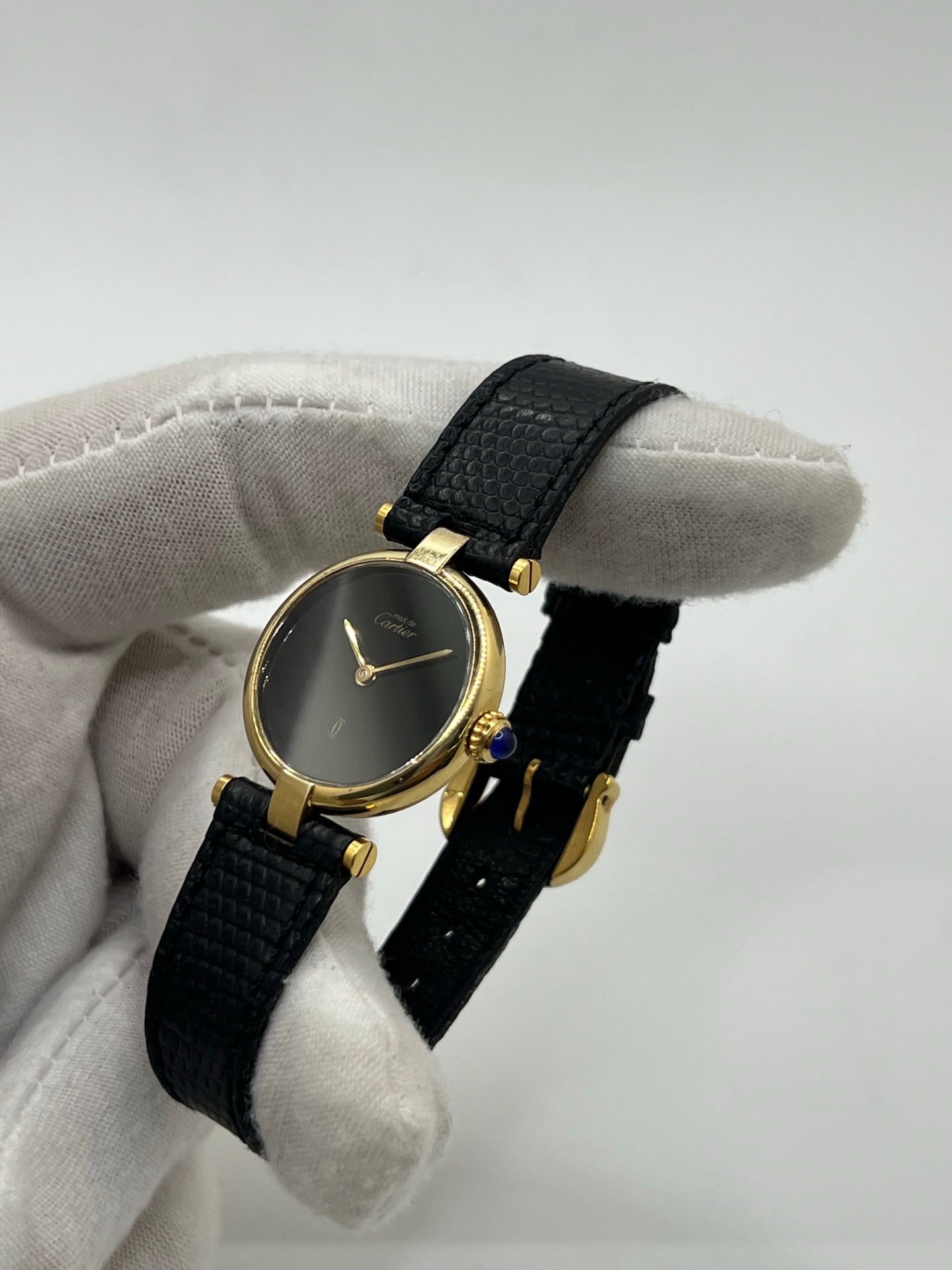 Montre Cartier Must de Cartier Vendome pour femme, boîtier argent de 24 mm avec cadran noir sans chiffres, mouvement quartz précis, verre saphir résistant aux rayures, bracelet cuir noir avec boucle ardillon en acier. État d’occasion très bon, livrée avec coffret d’origine. Élégante et intemporelle, idéale pour collection ou usage quotidien.