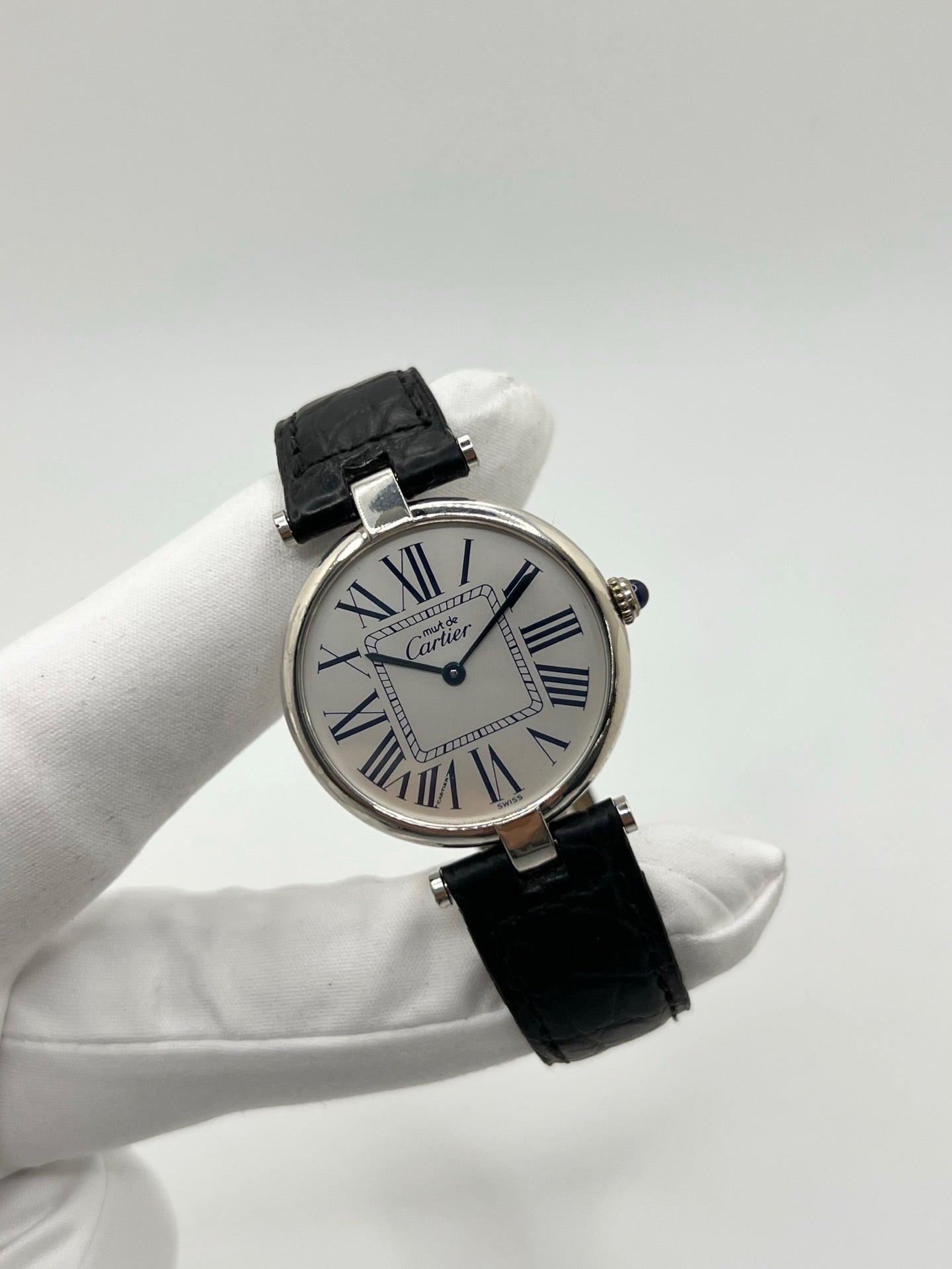 Montre Cartier Must Vendôme référence 1860 avec boîtier rond en argent de 30 mm et cadran argent à chiffres romains signature. Mouvement quartz fiable et élégant, protégé par un verre. Bracelet en cuir noir avec boucle ardillon offrant un porté confortable et raffiné. Modèle emblématique au style classique et intemporel, idéal pour une tenue habillée ou une collection de montres vintage. Montre d’occasion en très bon état, révisée et prête à être portée au quotidien.