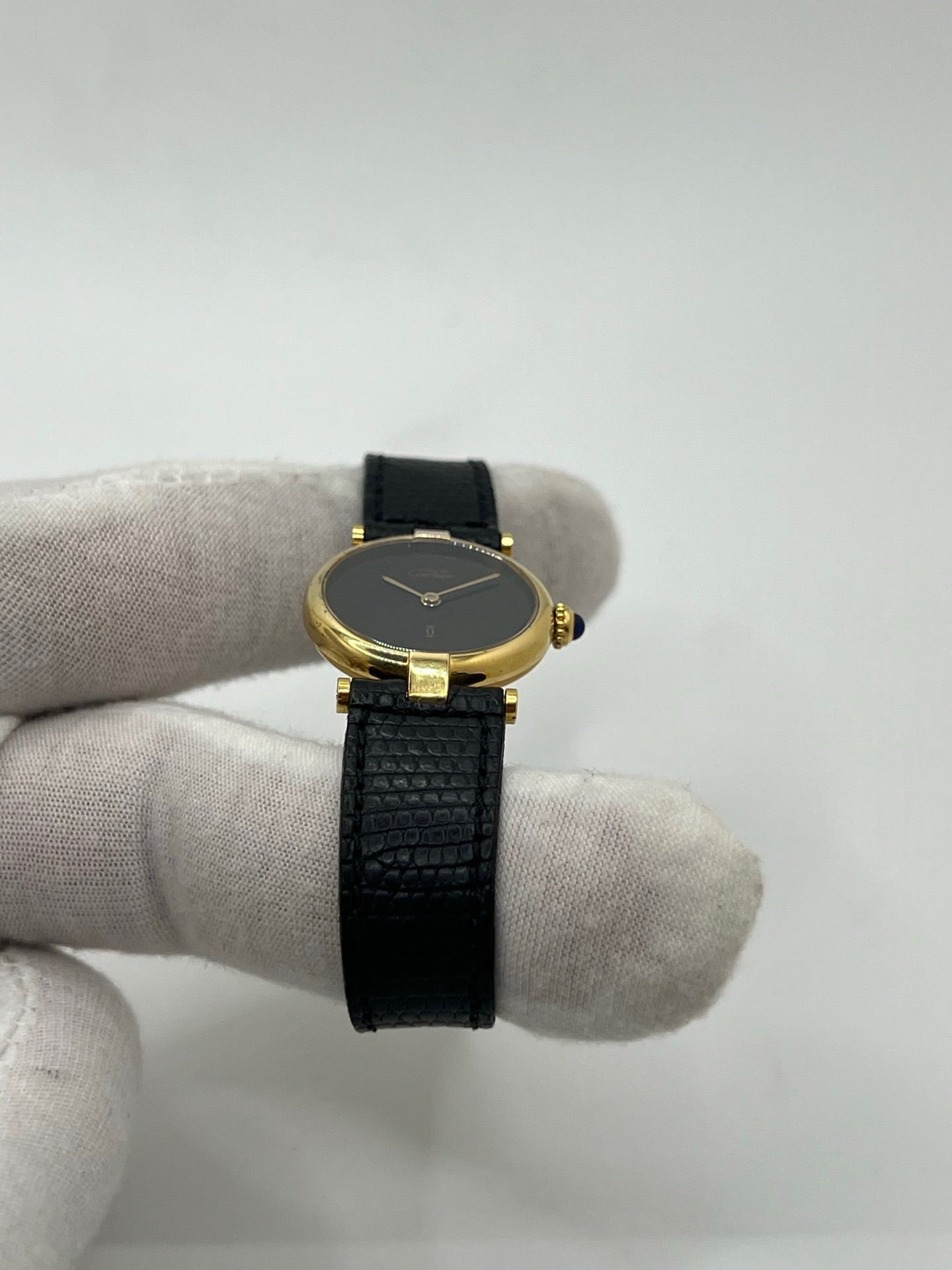 Montre Cartier Must de Cartier Vendome pour femme, boîtier argent de 24 mm avec cadran noir sans chiffres, mouvement quartz précis, verre saphir résistant aux rayures, bracelet cuir noir avec boucle ardillon en acier. État d’occasion très bon, livrée avec coffret d’origine. Élégante et intemporelle, idéale pour collection ou usage quotidien.