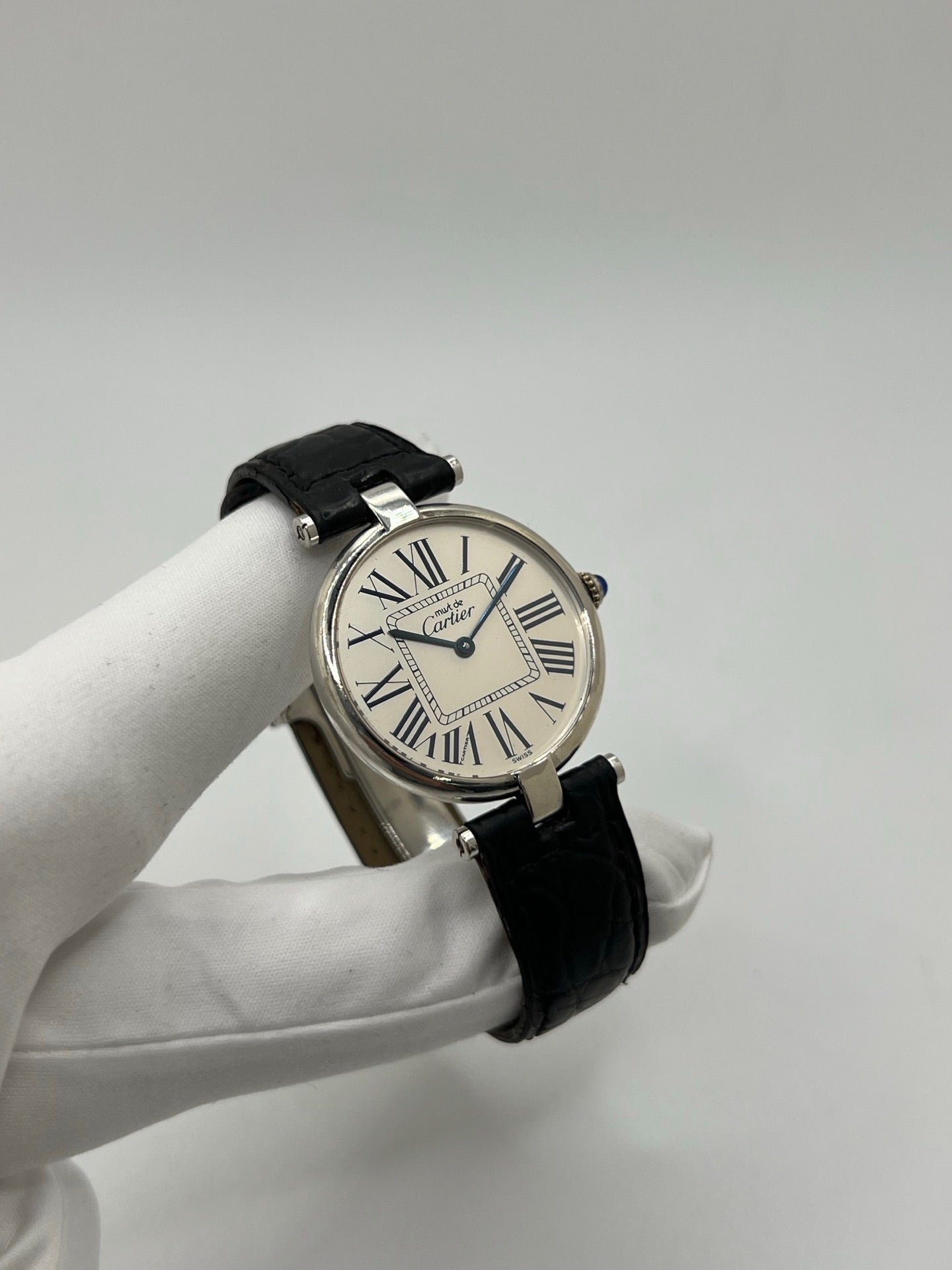 Montre Cartier Must Vendôme référence 1860 avec boîtier rond en argent de 30 mm et cadran argent à chiffres romains signature. Mouvement quartz fiable et élégant, protégé par un verre. Bracelet en cuir noir avec boucle ardillon offrant un porté confortable et raffiné. Modèle emblématique au style classique et intemporel, idéal pour une tenue habillée ou une collection de montres vintage. Montre d’occasion en très bon état, révisée et prête à être portée au quotidien.