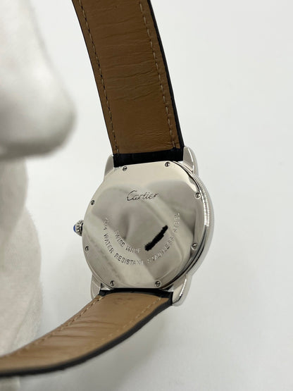 Montre Cartier Ronde Solo en acier avec cadran argent à chiffres romains, mouvement quartz et fonction date. Boîtier rond 36 x 39 mm avec verre saphir et étanchéité 3 ATM. Bracelet en cuir noir avec boucle ardillon en acier. Design classique et élégant, idéal pour homme ou unisexe. Montre d’occasion en très bon état, révisée, avec coffret d’origine.