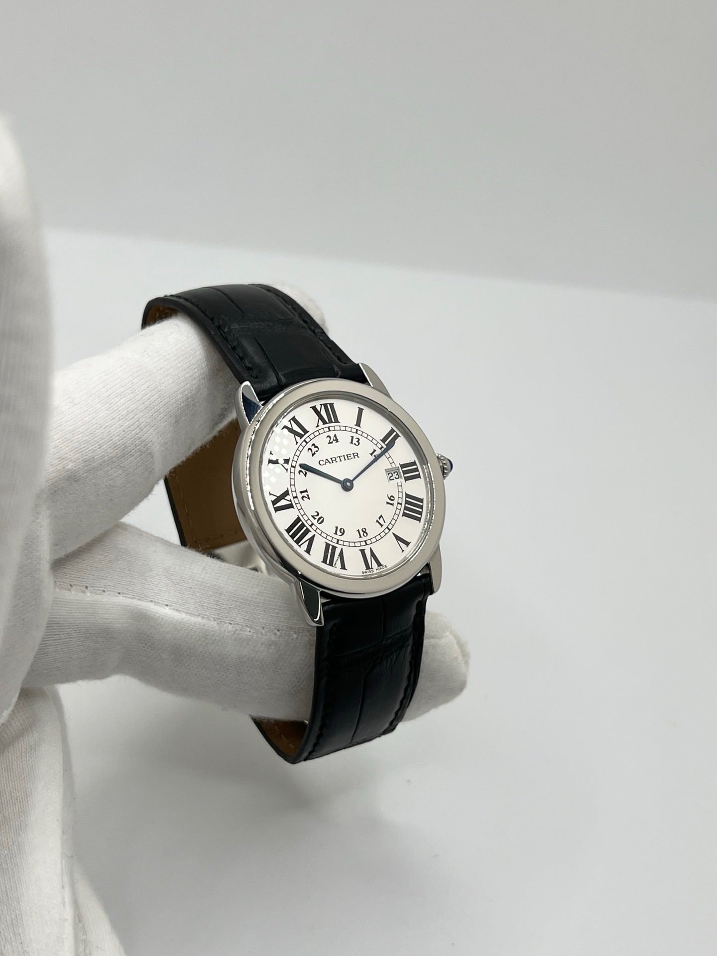 Montre Cartier Ronde Solo en acier avec cadran argent à chiffres romains, mouvement quartz et fonction date. Boîtier rond 36 x 39 mm avec verre saphir et étanchéité 3 ATM. Bracelet en cuir noir avec boucle ardillon en acier. Design classique et élégant, idéal pour homme ou unisexe. Montre d’occasion en très bon état, révisée, avec coffret d’origine.