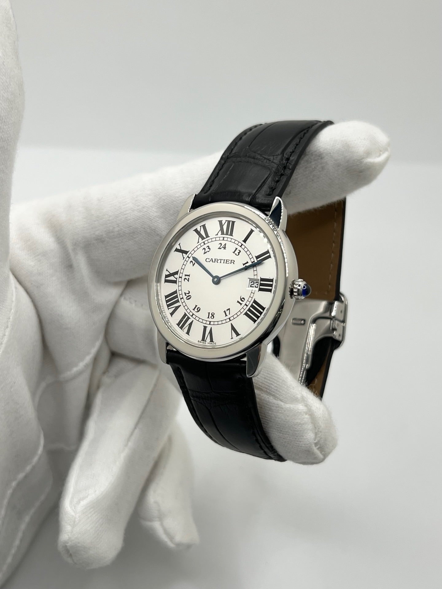 Montre Cartier Ronde Solo en acier avec cadran argent à chiffres romains, mouvement quartz et fonction date. Boîtier rond 36 x 39 mm avec verre saphir et étanchéité 3 ATM. Bracelet en cuir noir avec boucle ardillon en acier. Design classique et élégant, idéal pour homme ou unisexe. Montre d’occasion en très bon état, révisée, avec coffret d’origine.