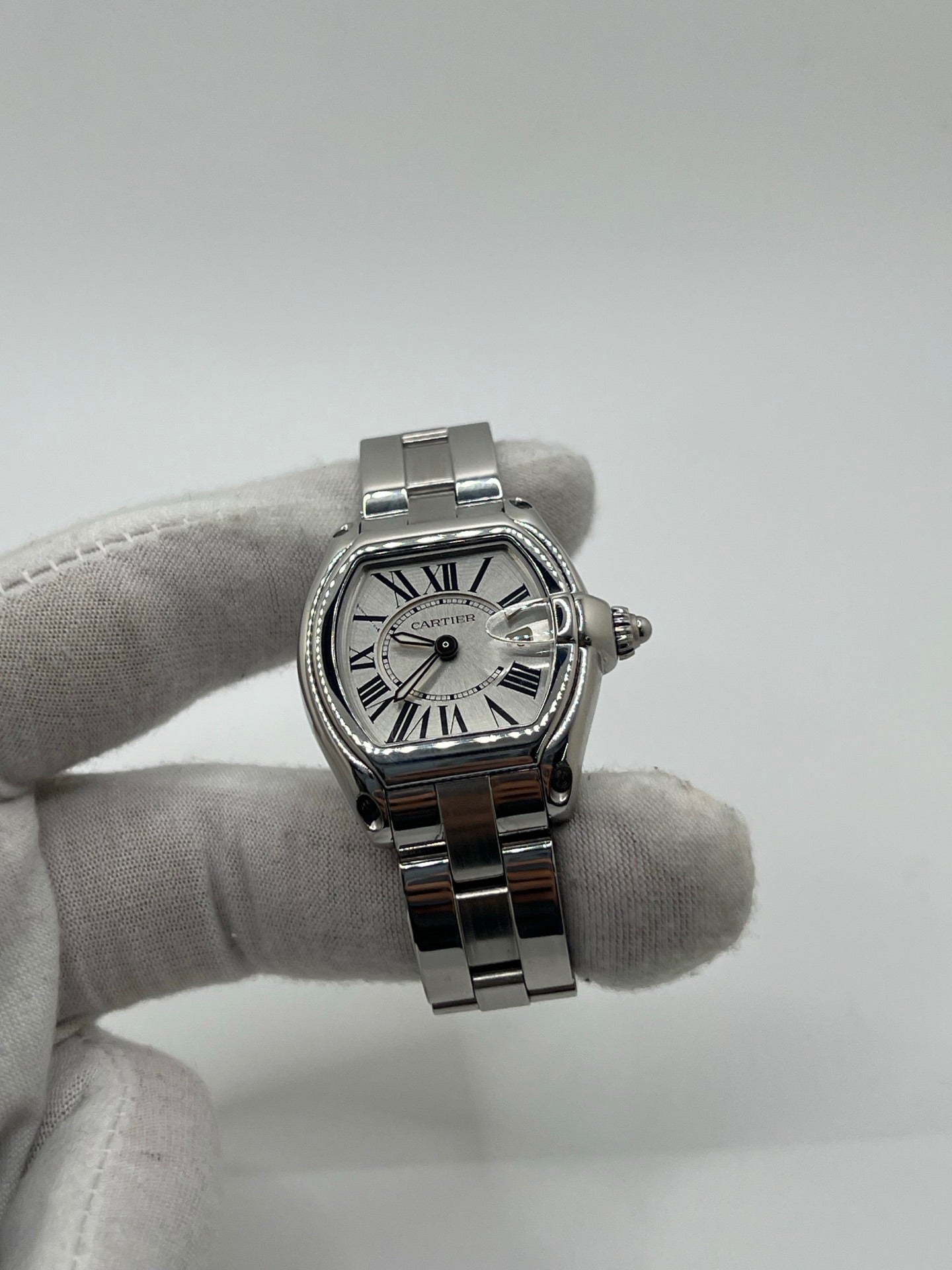 Montre Cartier Roadster 2675 pour femme en acier, équipée d’un mouvement quartz calibre 688. Boîtier 31 x 37 mm avec verre saphir, cadran argent à chiffres romains et bracelet acier à boucle déployante. Modèle étanche à 10 ATM avec fonction date, livré avec coffret d’origine, en très bon état d’occasion.