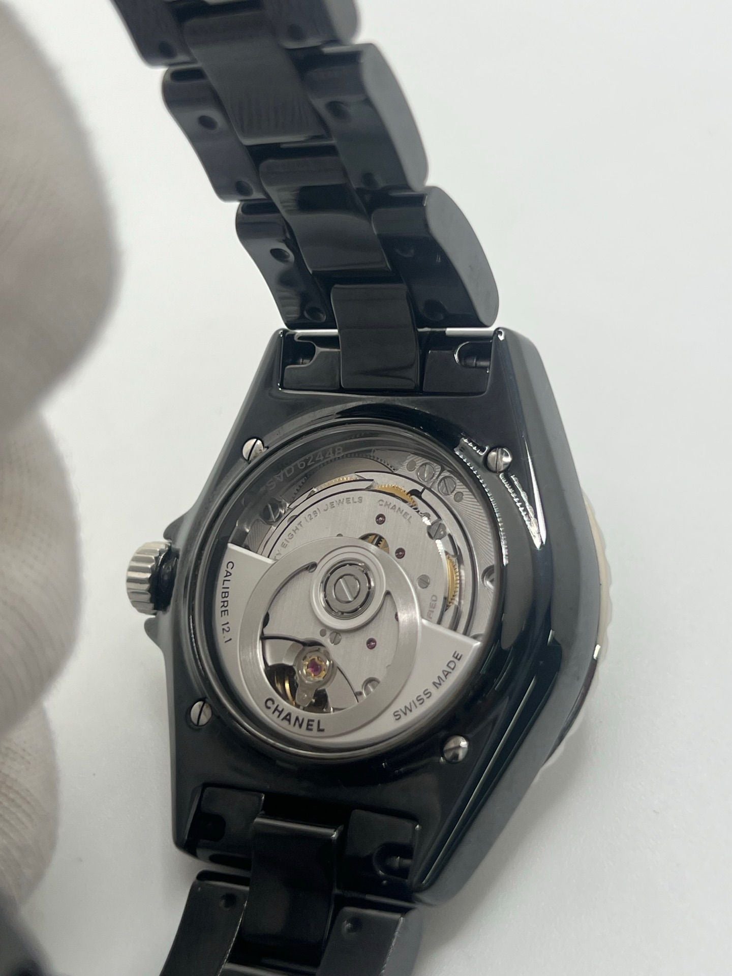 Montre Chanel J12 12.1 en céramique noire avec sertissage de diamants, alliant élégance et performance. Mouvement automatique de précision, boîtier de 38 mm et verre saphir. Modèle de luxe d'occasion en excellent état, livré avec coffret d'origine. Idéal pour collectionneurs et amateurs de haute horlogerie.