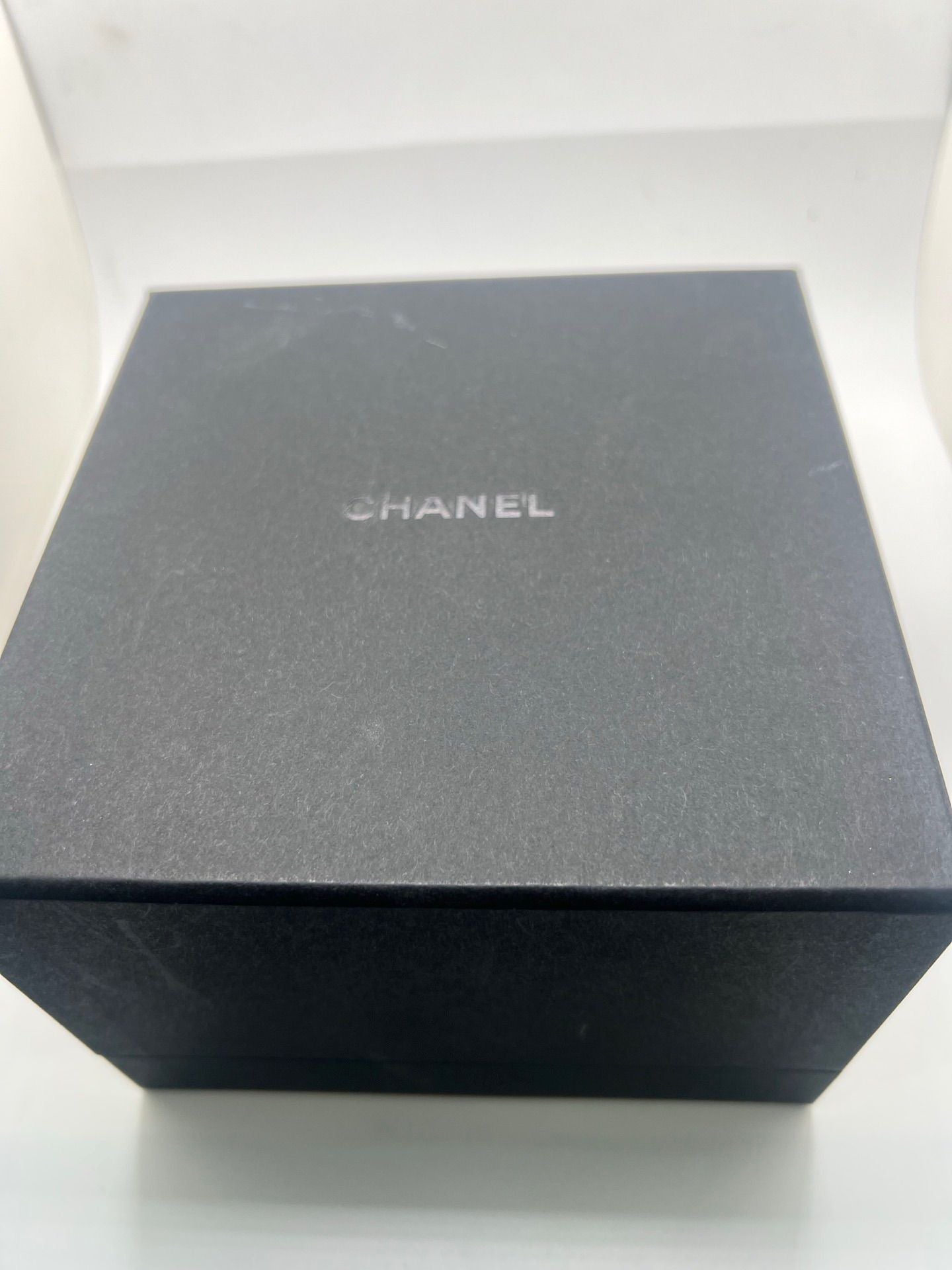 Montre Chanel J12 12.1 en céramique noire avec sertissage de diamants, alliant élégance et performance. Mouvement automatique de précision, boîtier de 38 mm et verre saphir. Modèle de luxe d'occasion en excellent état, livré avec coffret d'origine. Idéal pour collectionneurs et amateurs de haute horlogerie.