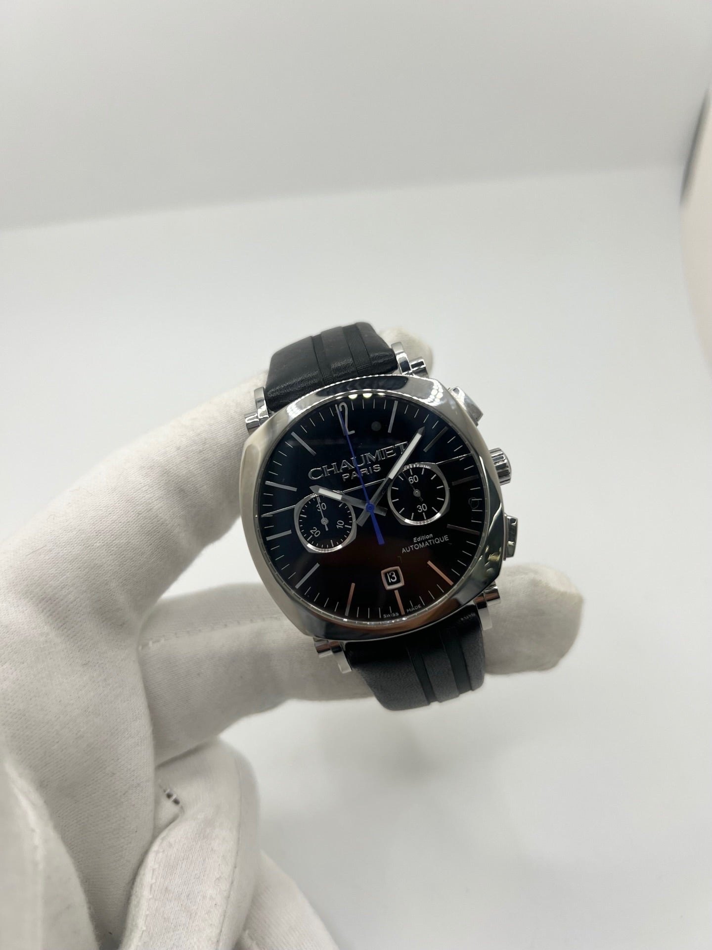 Montre Chaumet Dandy réf. 1229 pour homme ou unisexe, dotée d’un mouvement automatique. Boîtier en acier de 40 mm avec lunette assortie et verre saphir résistant aux rayures. Cadran noir à index bâtons, fonction chronographe et affichage de la date. Bracelet en cuir noir avec boucle déployante en acier. Montre de luxe d’occasion en très bon état, présentant de légères traces d’usure. Révisée en interne le 23 juin 2026, livrée avec coffret d’origine, sans papiers. Disponible à Paris. 