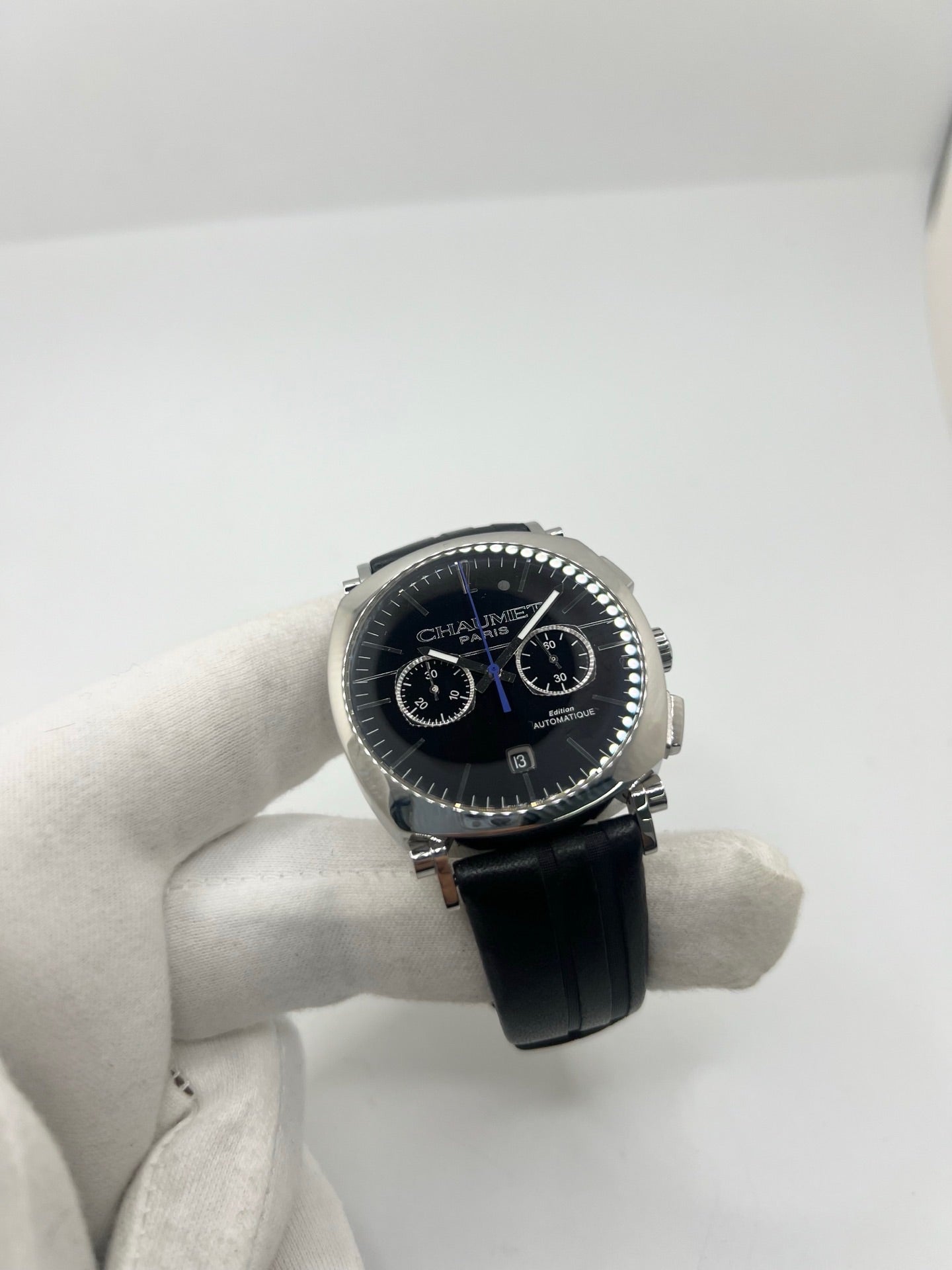 Montre Chaumet Dandy réf. 1229 pour homme ou unisexe, dotée d’un mouvement automatique. Boîtier en acier de 40 mm avec lunette assortie et verre saphir résistant aux rayures. Cadran noir à index bâtons, fonction chronographe et affichage de la date. Bracelet en cuir noir avec boucle déployante en acier. Montre de luxe d’occasion en très bon état, présentant de légères traces d’usure. Révisée en interne le 23 juin 2026, livrée avec coffret d’origine, sans papiers. Disponible à Paris. 