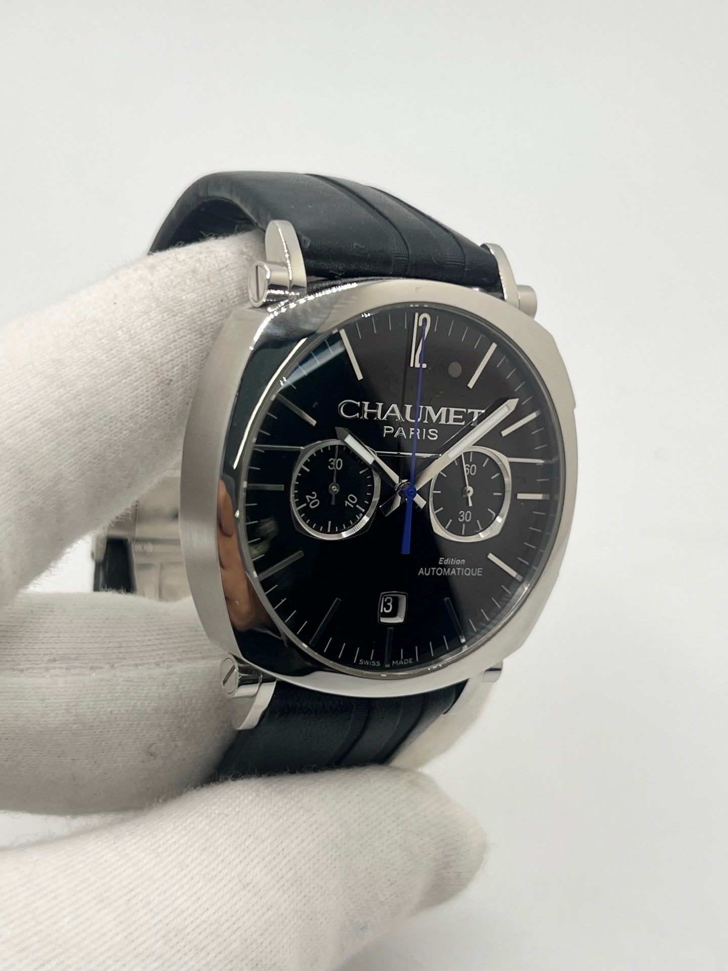 Montre Chaumet Dandy réf. 1229 pour homme ou unisexe, dotée d’un mouvement automatique. Boîtier en acier de 40 mm avec lunette assortie et verre saphir résistant aux rayures. Cadran noir à index bâtons, fonction chronographe et affichage de la date. Bracelet en cuir noir avec boucle déployante en acier. Montre de luxe d’occasion en très bon état, présentant de légères traces d’usure. Révisée en interne le 23 juin 2026, livrée avec coffret d’origine, sans papiers. Disponible à Paris. 
