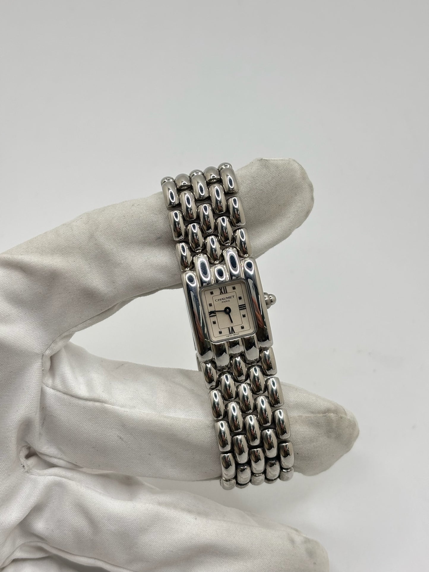 Montre Chaumet Khesis femme en acier avec mouvement quartz, cadran blanc à chiffres romains et verre saphir. Cette montre de luxe au design joaillier emblématique se distingue par son boîtier rectangulaire de 21 x 17 mm et son bracelet en acier intégré. Élégante et raffinée, cette Chaumet Khesis vintage de 1998 est accompagnée de ses papiers d’origine. Montre femme d’occasion en très bon état, idéale pour les collectionneuses et amatrices d’horlogerie de prestige.
