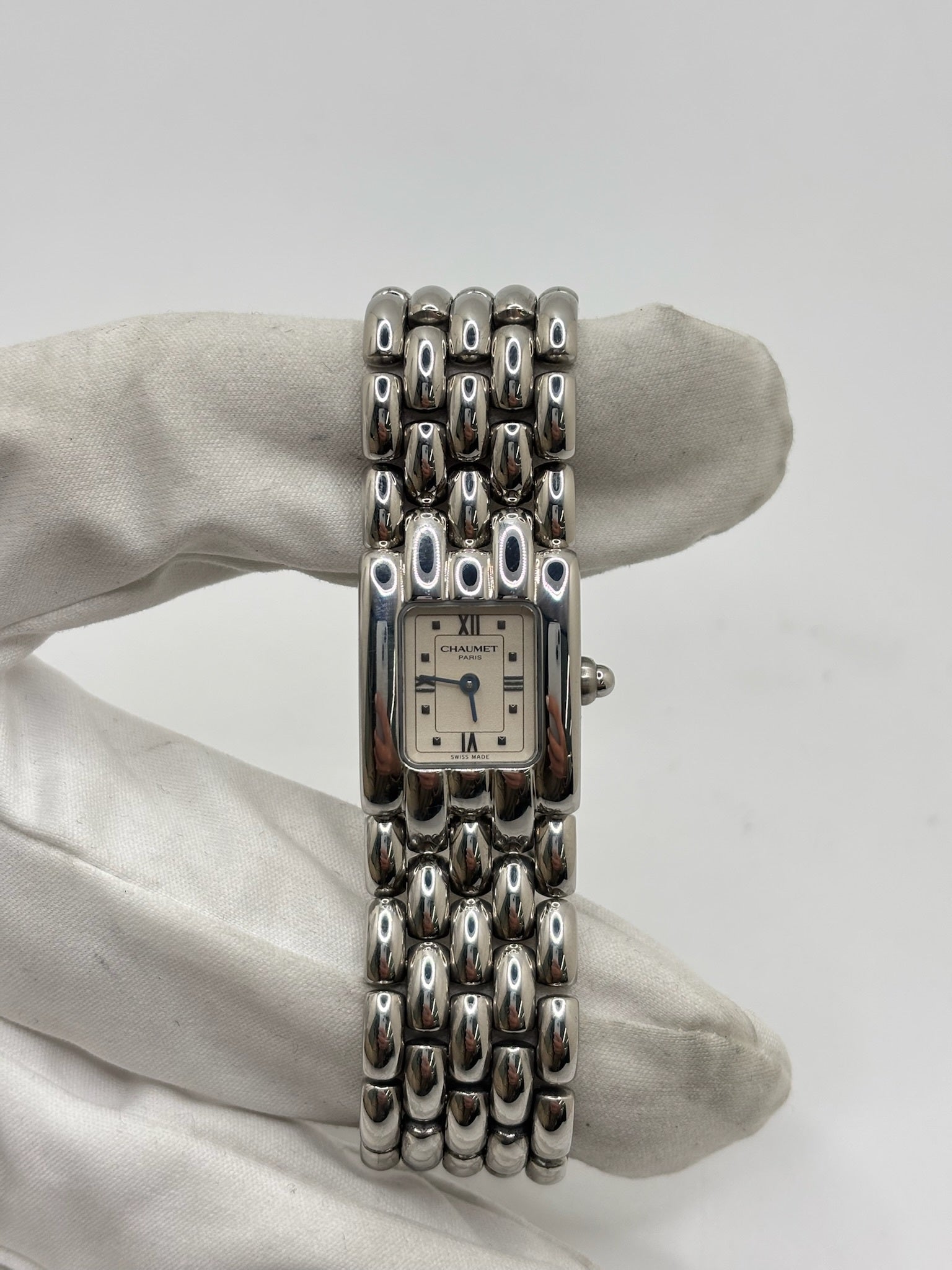 Montre Chaumet Khesis femme en acier avec mouvement quartz, cadran blanc à chiffres romains et verre saphir. Cette montre de luxe au design joaillier emblématique se distingue par son boîtier rectangulaire de 21 x 17 mm et son bracelet en acier intégré. Élégante et raffinée, cette Chaumet Khesis vintage de 1998 est accompagnée de ses papiers d’origine. Montre femme d’occasion en très bon état, idéale pour les collectionneuses et amatrices d’horlogerie de prestige.