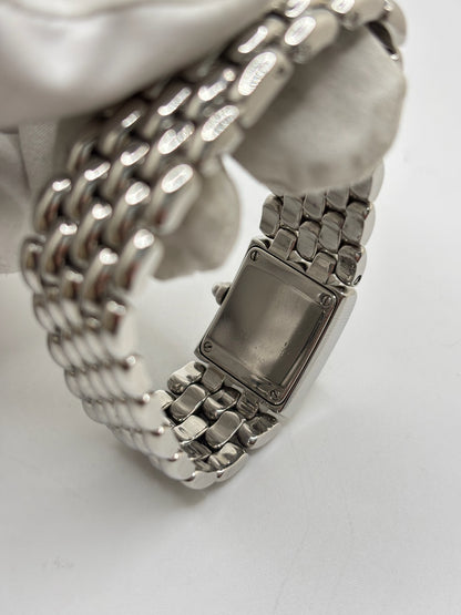 Montre Chaumet Khesis femme en acier avec mouvement quartz, cadran blanc à chiffres romains et verre saphir. Cette montre de luxe au design joaillier emblématique se distingue par son boîtier rectangulaire de 21 x 17 mm et son bracelet en acier intégré. Élégante et raffinée, cette Chaumet Khesis vintage de 1998 est accompagnée de ses papiers d’origine. Montre femme d’occasion en très bon état, idéale pour les collectionneuses et amatrices d’horlogerie de prestige.