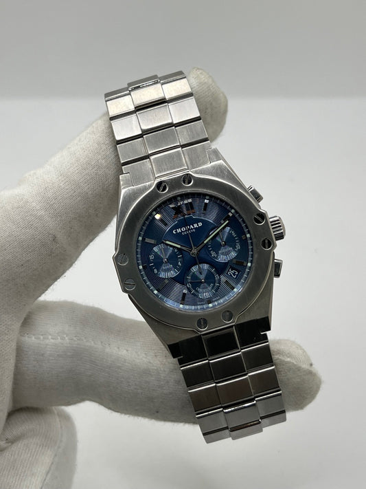 Montre Chopard St. Moritz référence 8386 en acier avec boîtier de 37 mm, animée par un mouvement automatique équipé du calibre 1185. Son cadran bleu à chiffres romains est protégé par un verre saphir et complété par un bracelet en acier avec boucle déployante. Dotée des fonctions chronographe et date, cette montre Chopard d'occasion est en très bon état, révisée en interne et livrée avec son coffret d'origine, sans papiers.