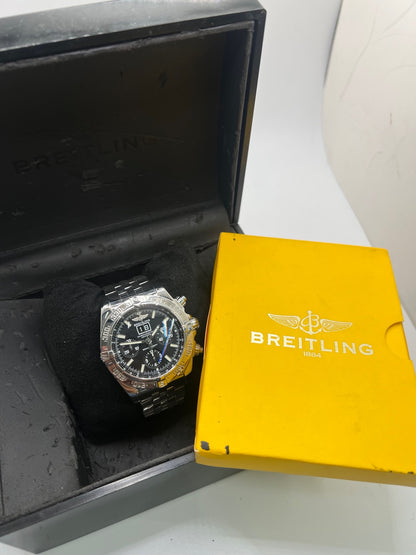 Breitling Blackbird référence A44359, chronographe automatique pour homme avec boîtier en acier de 44 mm et bracelet acier assorti. Cadran noir sans chiffres offrant une lecture claire, protégé par un verre saphir résistant aux rayures. Lunette acier et étanchéité jusqu’à 30 ATM. Équipée du calibre Breitling 44 avec réserve de marche d’environ 42 heures, fonction chronographe et date. Modèle de 2010 en très bon état, révisé, livré avec coffret et papiers d’origine.