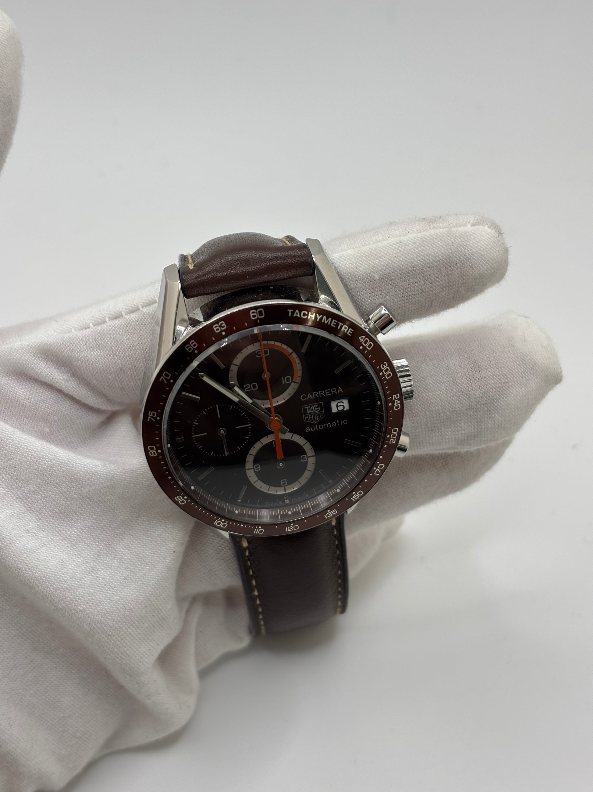 Montre chronographe automatique TAG Heuer Carrera Calibre 16 en acier de 41 mm, dotée d’un cadran brun élégant et d’un verre saphir résistant aux rayures. Ce modèle homme au design sportif et raffiné est équipé d’un mouvement automatique Calibre 16 offrant 42 heures de réserve de marche. Bracelet en cuir brun avec boucle déployante en acier, fonctions chronographe et date, étanchéité 5 ATM, montre suisse de caractère idéale pour un usage quotidien ou une collection horlogère.