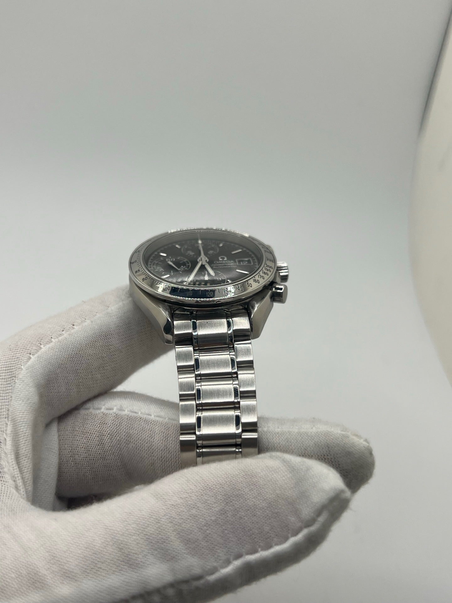 Montre Omega Speedmaster Date référence 3513.50 en acier, chronographe automatique avec boîtier de 39 mm et bracelet en acier assorti. Cadran noir sobre sans chiffres, protégé par un verre saphir, avec affichage de la date et fonctions chronographe. Modèle étanche 5 ATM, animé par le calibre automatique 1152 offrant 44 heures de réserve de marche. Montre homme élégante et sportive, emblématique de la collection Speedmaster.