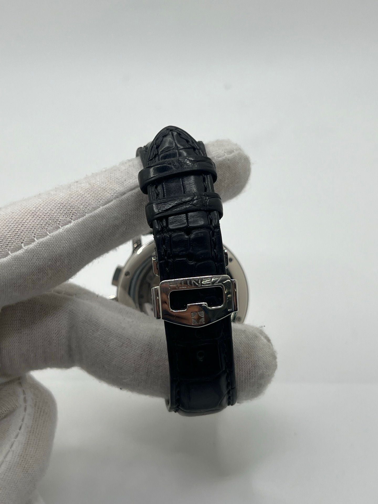 Montre chronographe automatique en acier avec cadran argenté à chiffres romains, fonction phase lunaire, date, jour et mois. Boîtier de 40 mm, verre saphir, fond transparent et bracelet en cuir noir. Modèle de haute précision doté du calibre 410 avec 50 heures de réserve de marche. Montre élégante pour homme ou unisexe.